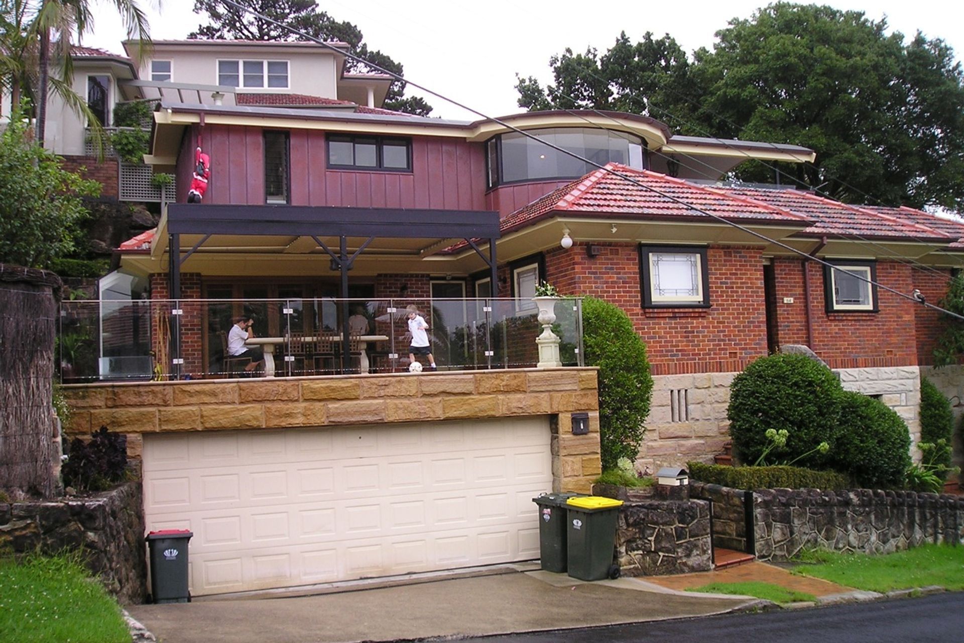 View from side street showing new upper level addition, bay window and covered deck