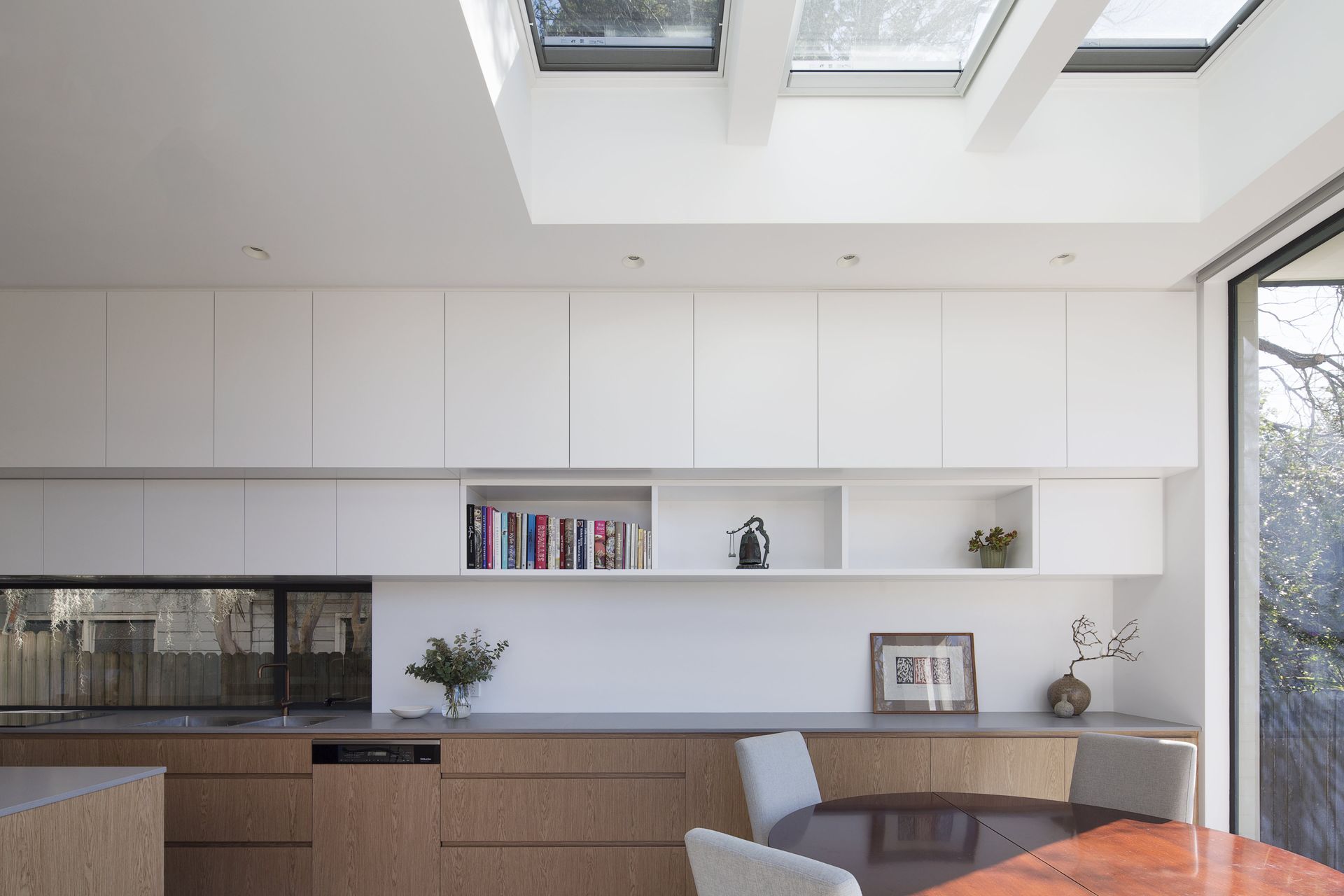 A simplistic kitchen layered with textured materials. A window splashback allowed for natural light to reflect into the space.