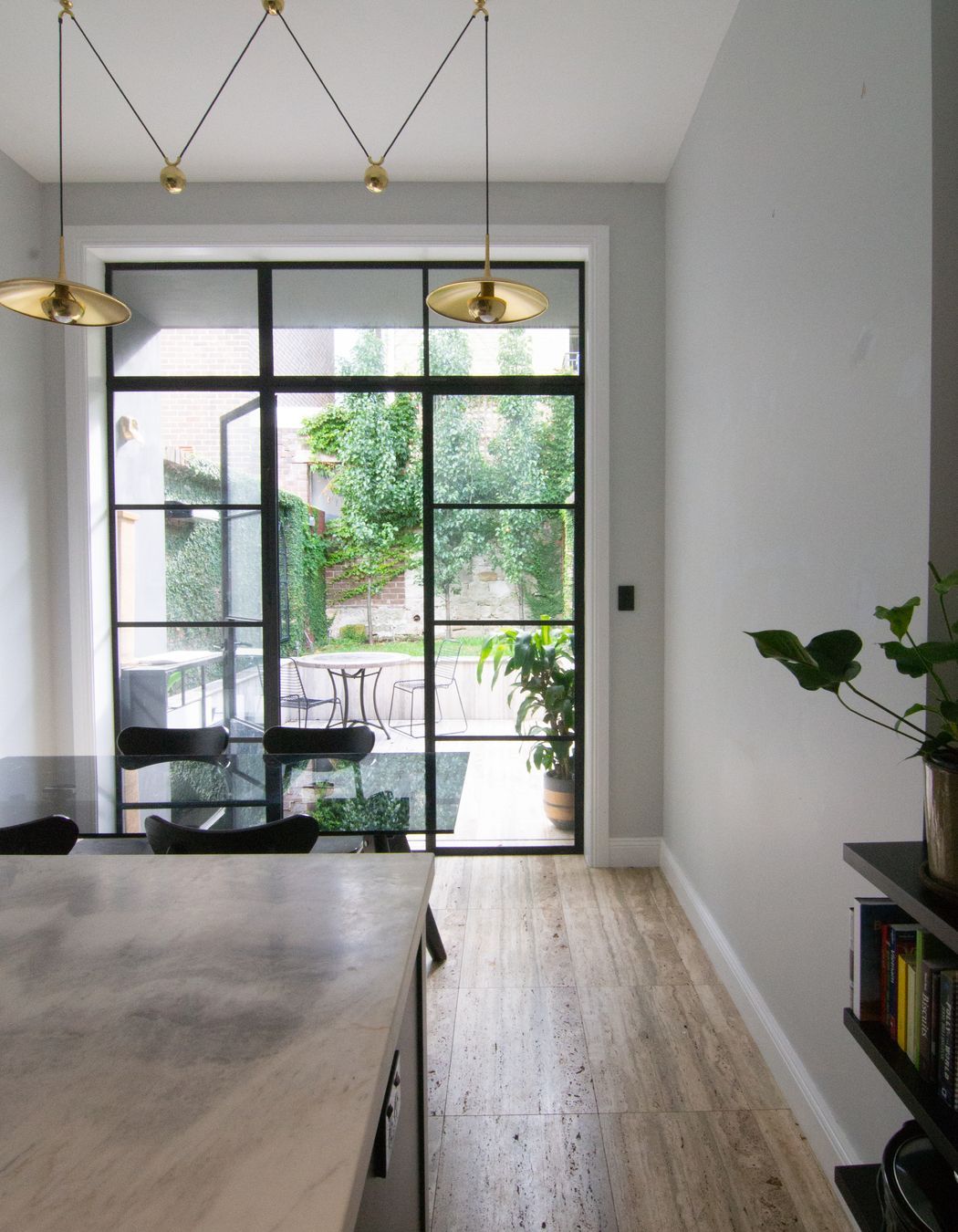 The steel doors create a thin and timeless threshold between the interior and exterior.