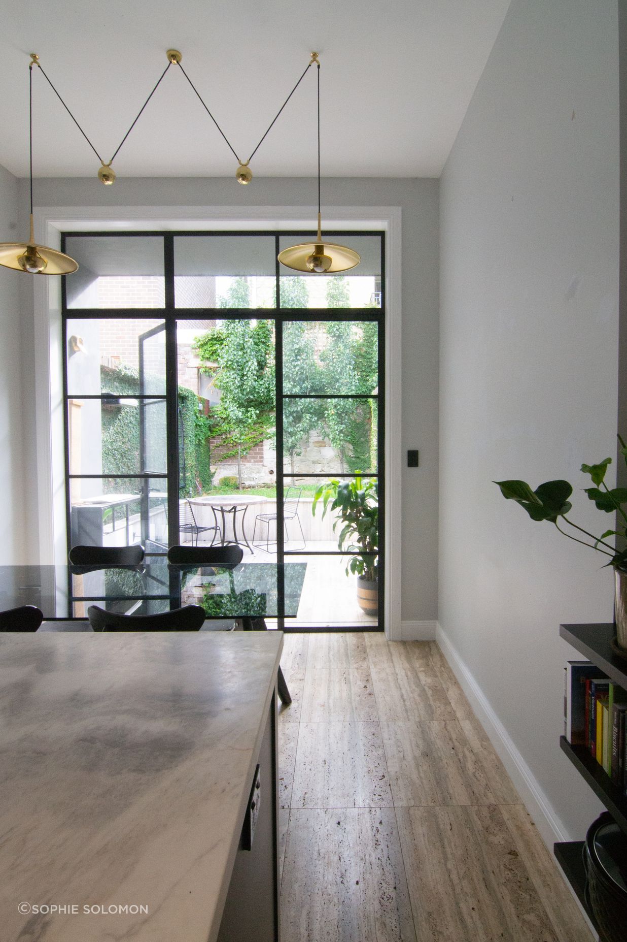 The steel doors create a thin and timeless threshold between the interior and exterior.