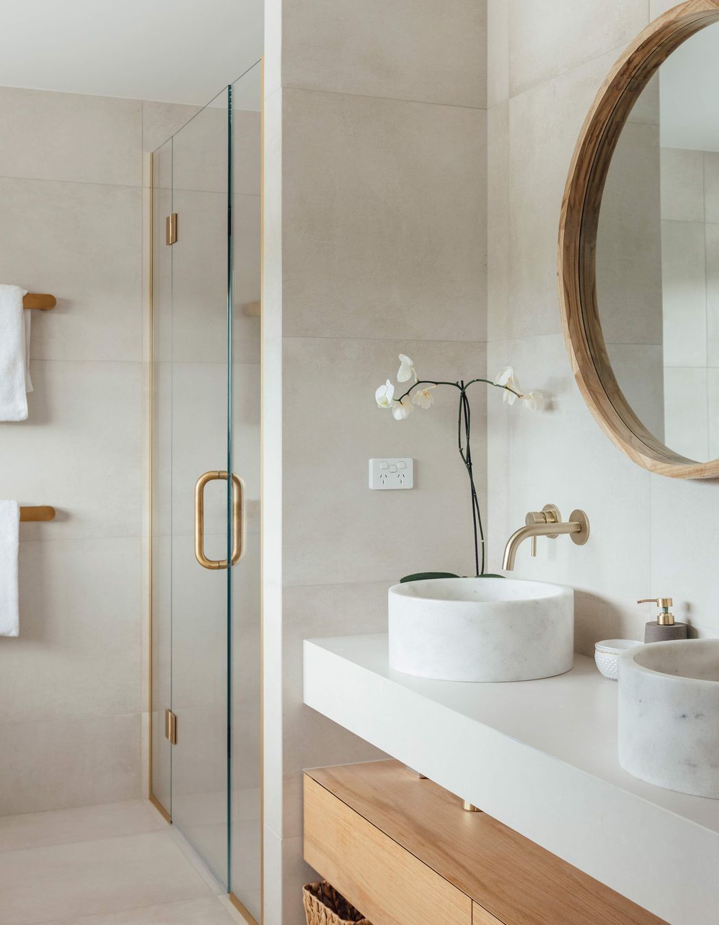 The main en suite bathroom continues the pared-back palette of muted tones and timbers.
