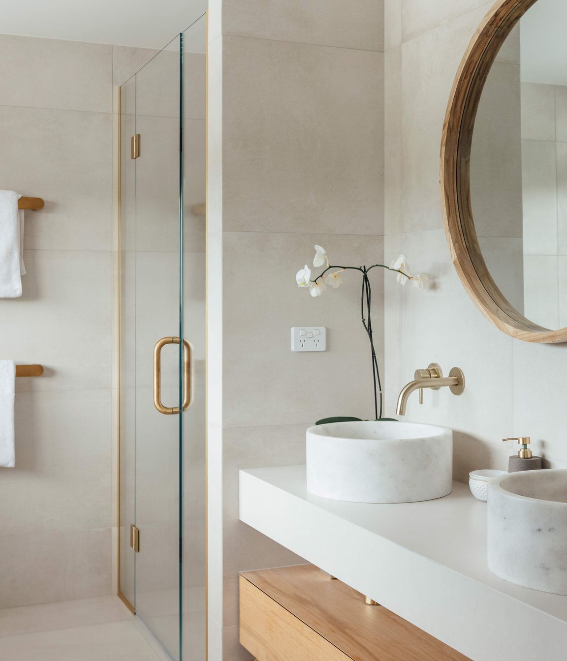 The main en suite bathroom continues the pared-back palette of muted tones and timbers.