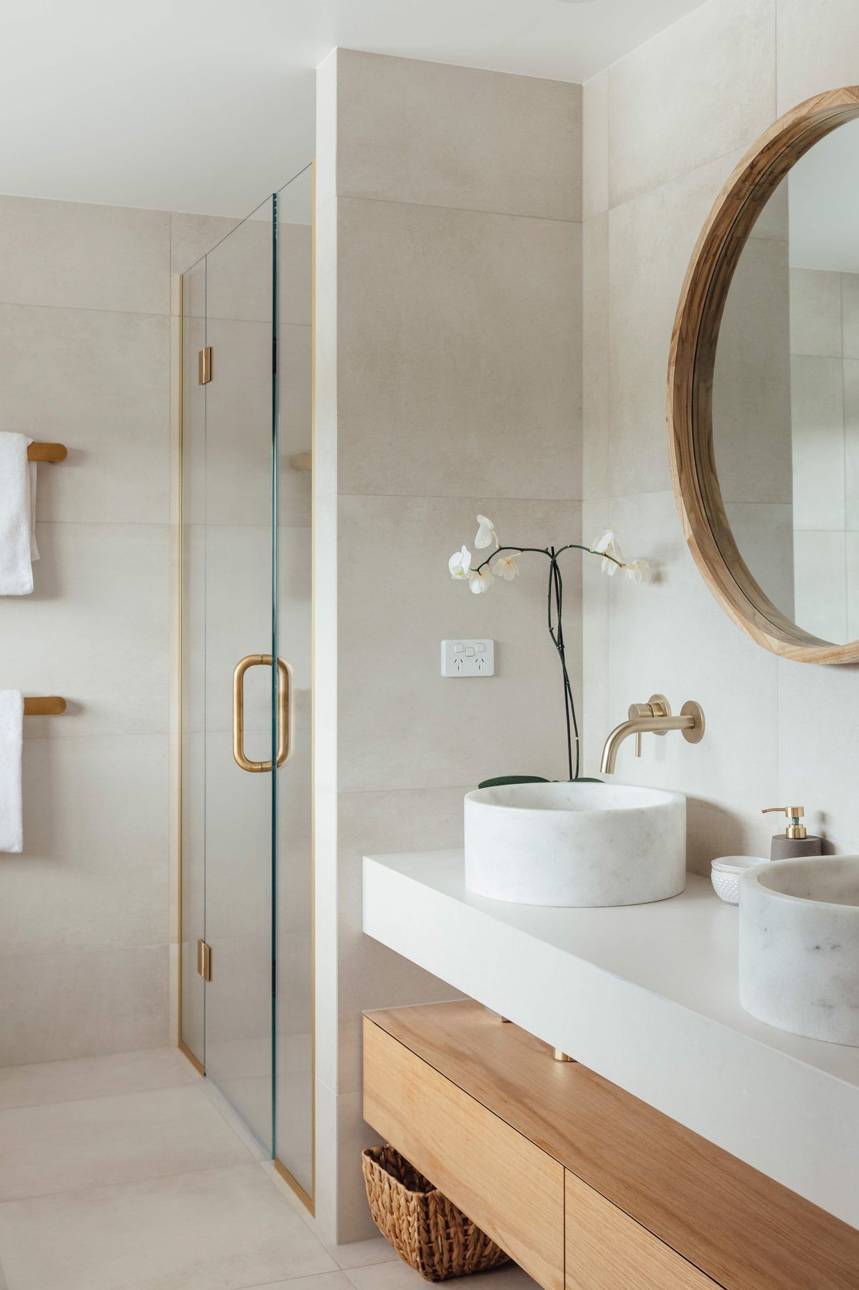The main en suite bathroom continues the pared-back palette of muted tones and timbers.