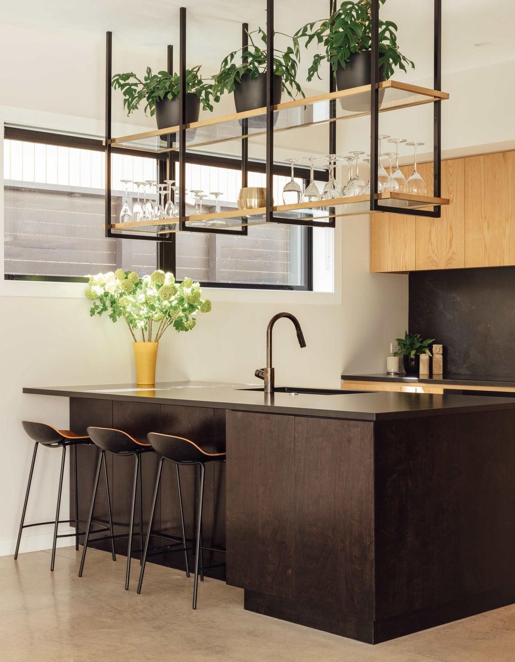 Suspended shelving above the island helps create a bar-like atmosphere around the kitchen.