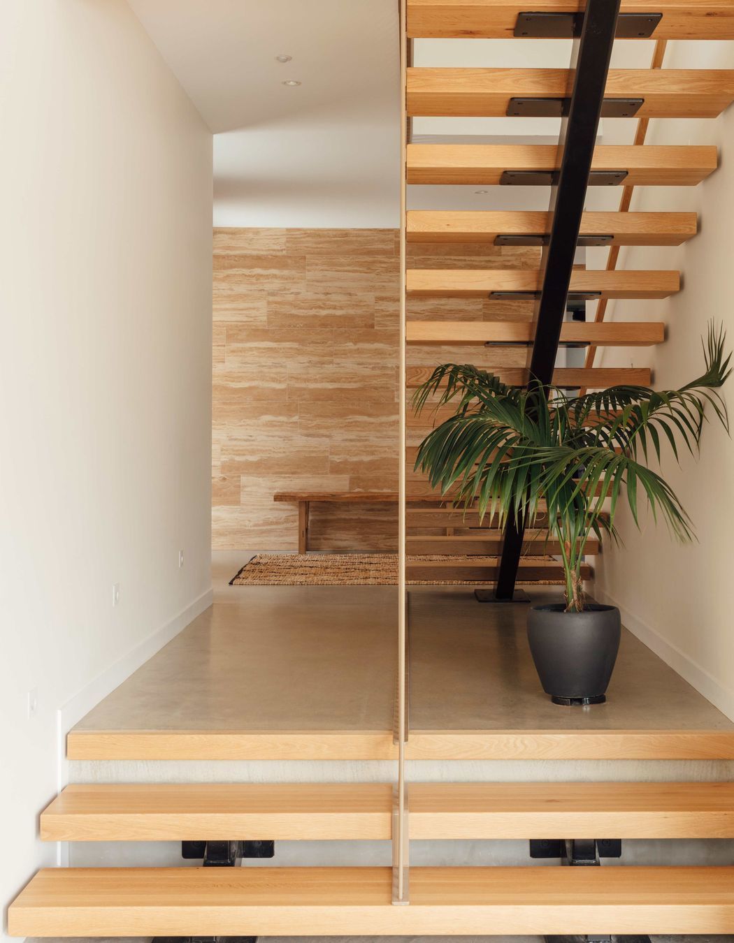 Stone-look tiles first encountered outside extend into the interior creating a feature element and setting up a recurring motif found in other spaces within the home.