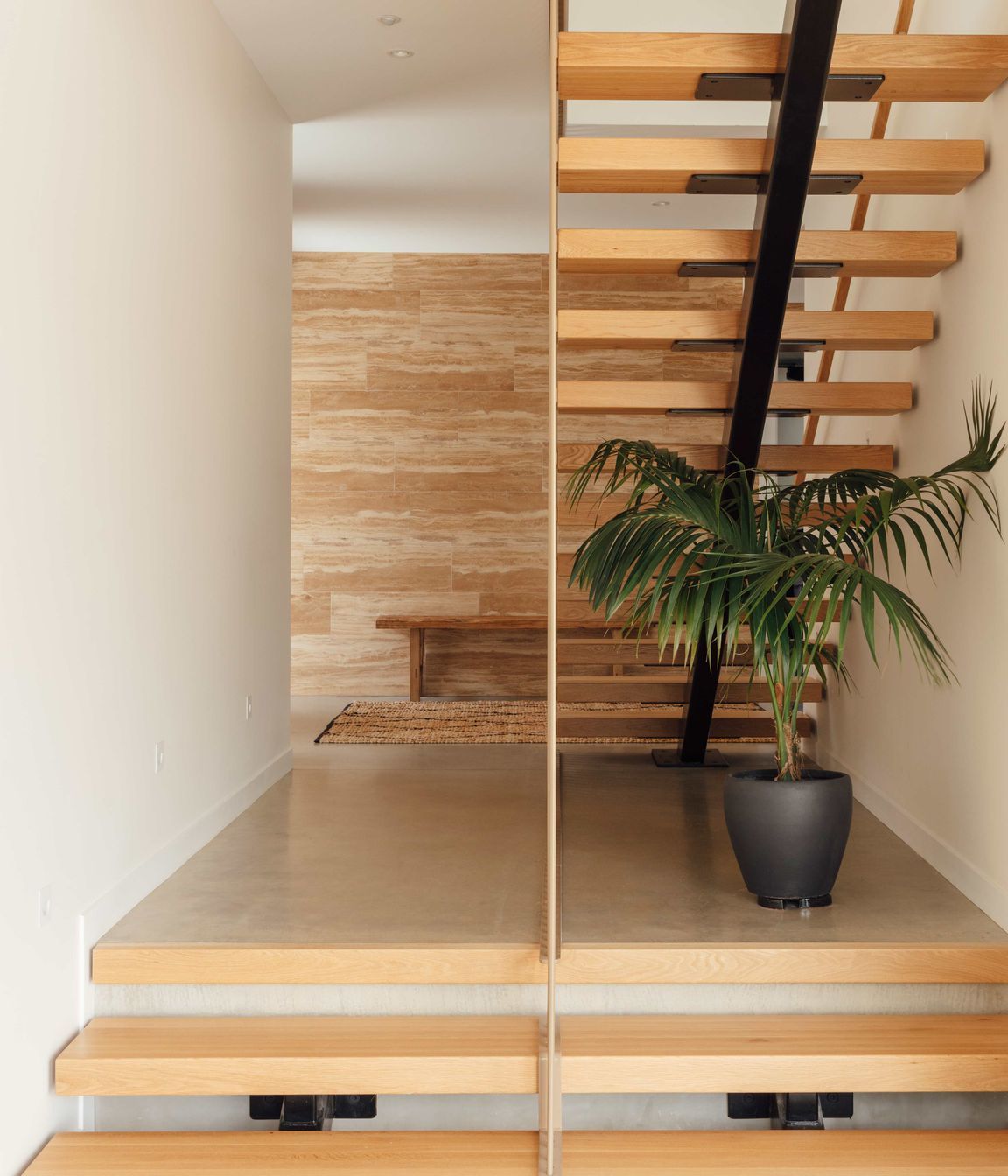 Stone-look tiles first encountered outside extend into the interior creating a feature element and setting up a recurring motif found in other spaces within the home.