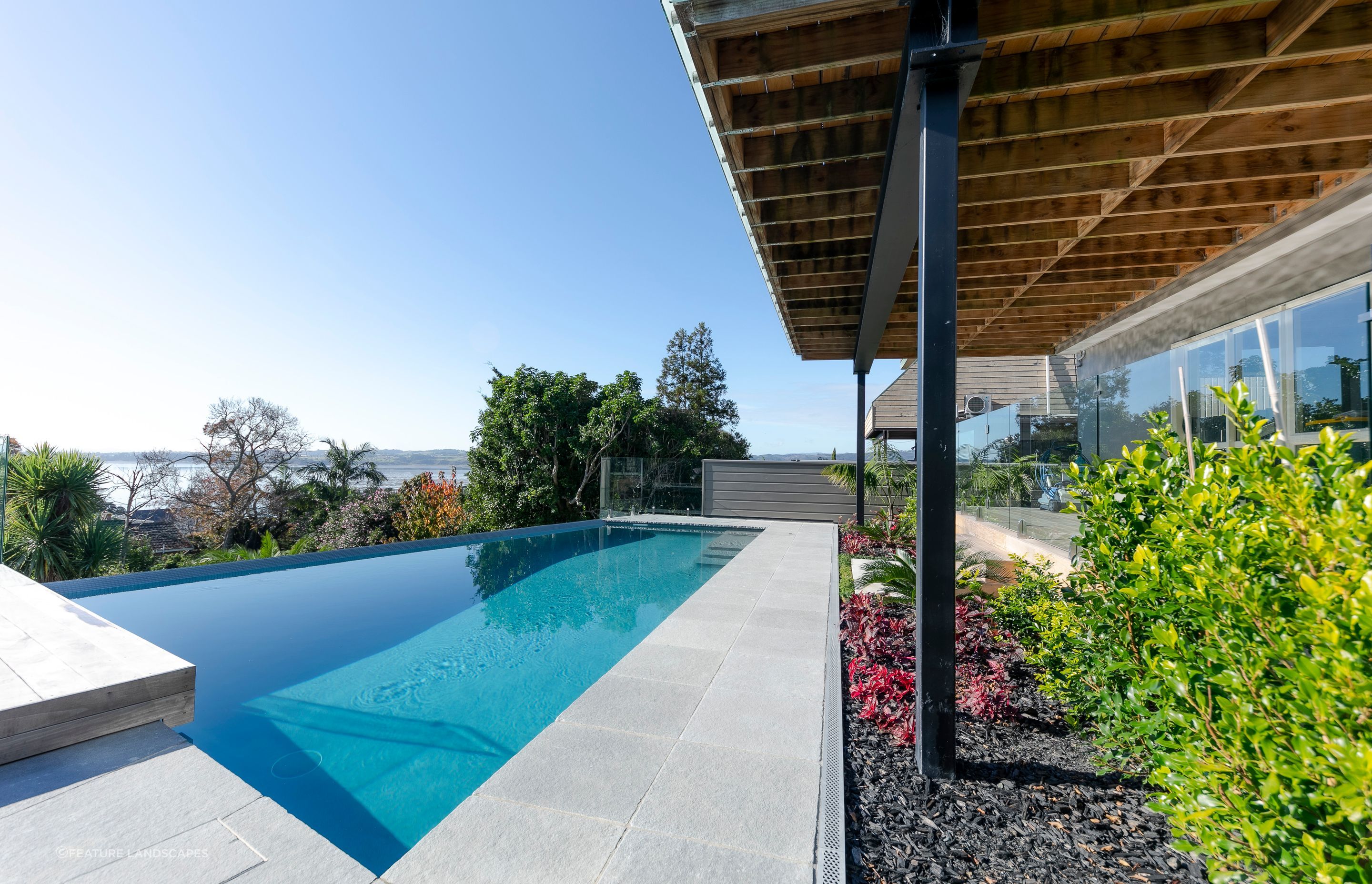 A huge transformation took place in this backyard - designed by Guy Brackebush.  Hydrazzo Hatteras Gray Pool Plaster captures the peep of the view out to Shelley Park Beach.
