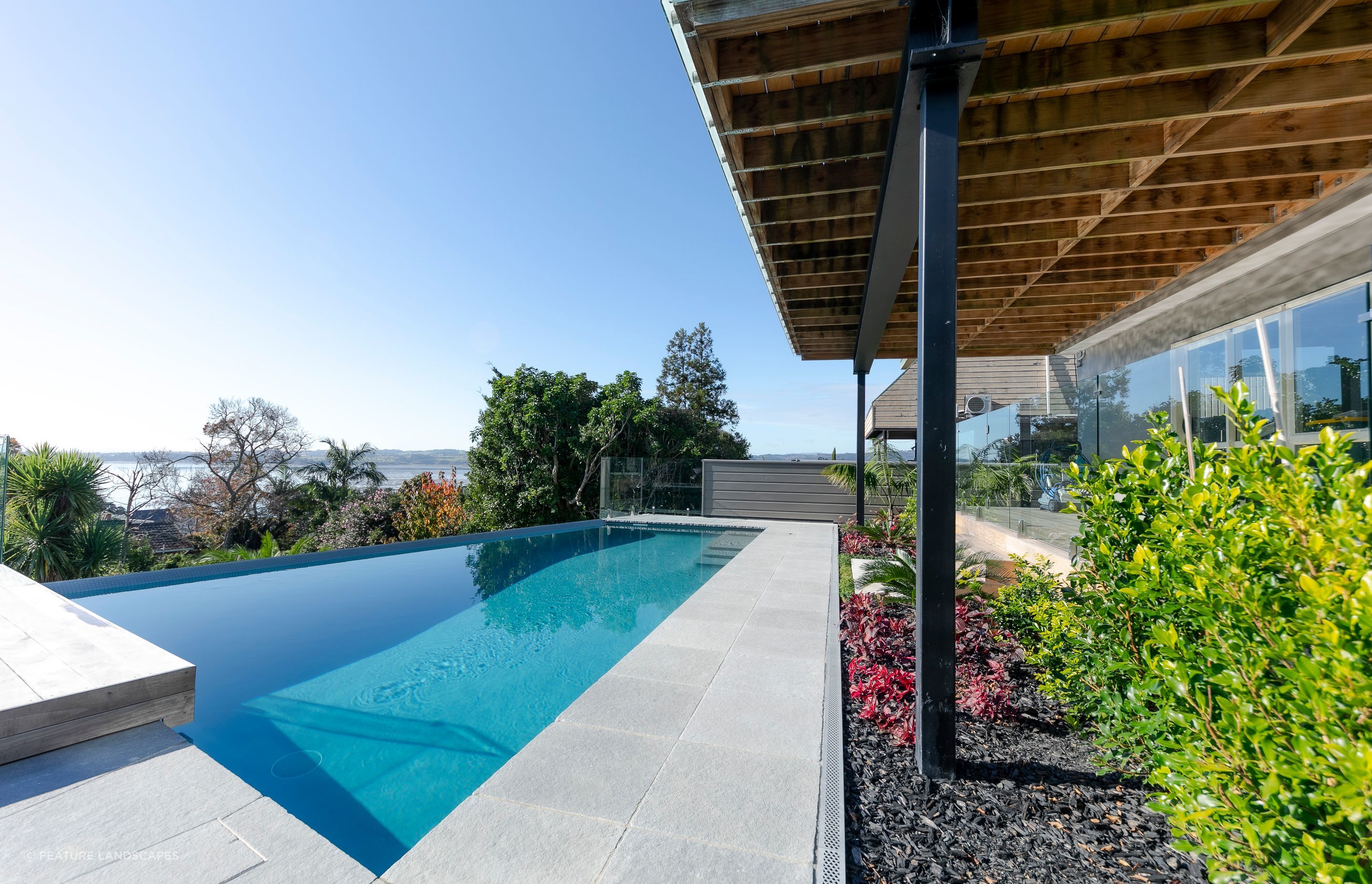 A huge transformation took place in this backyard - designed by Guy Brackebush. Hydrazzo Hatteras Gray Pool Plaster captures the peep of the view out to Shelley Park Beach.