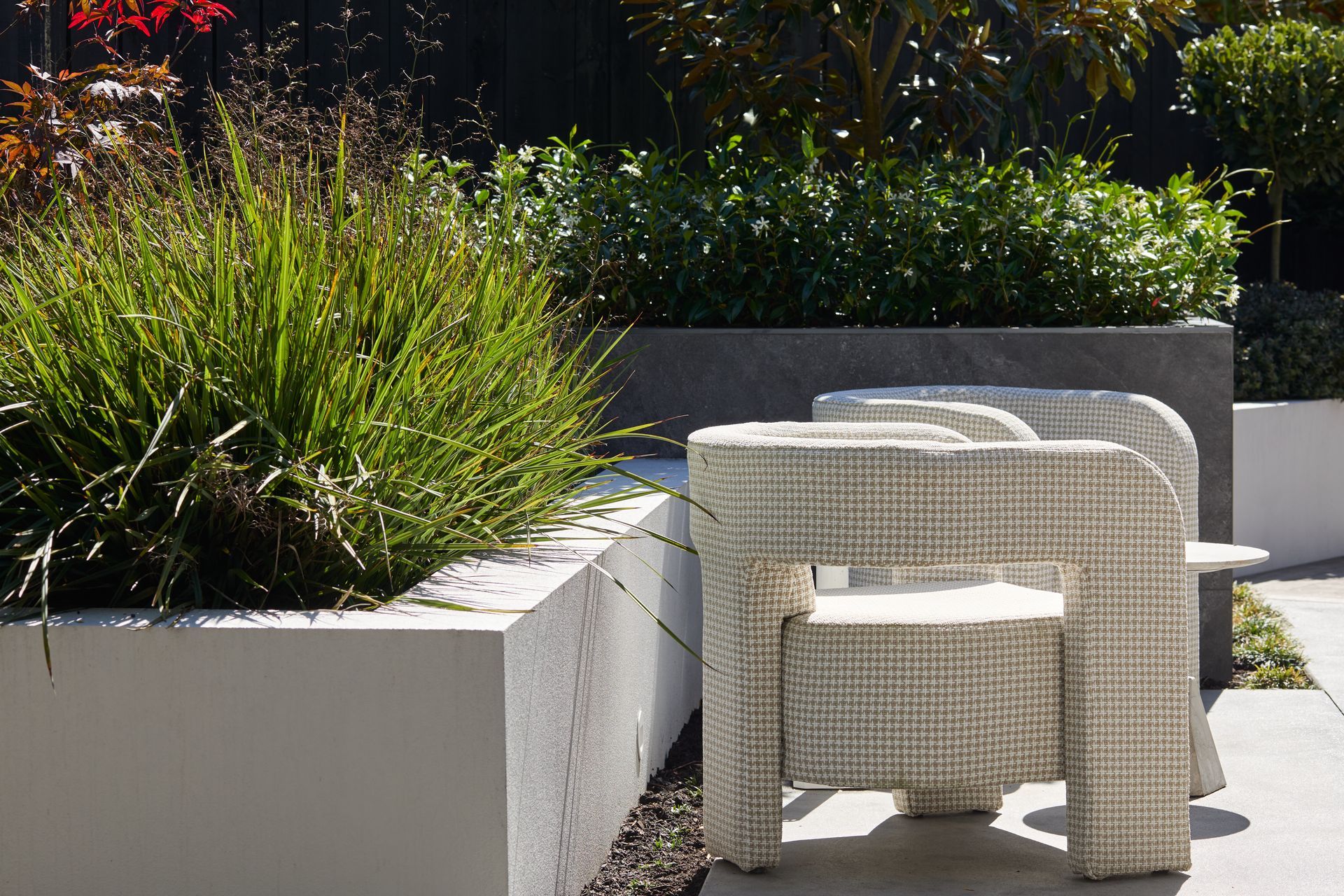 Mixed height raised planters helped define the main outdoor areas, blend the house into the landscape while also providing height, depth and privacy to the backyard.