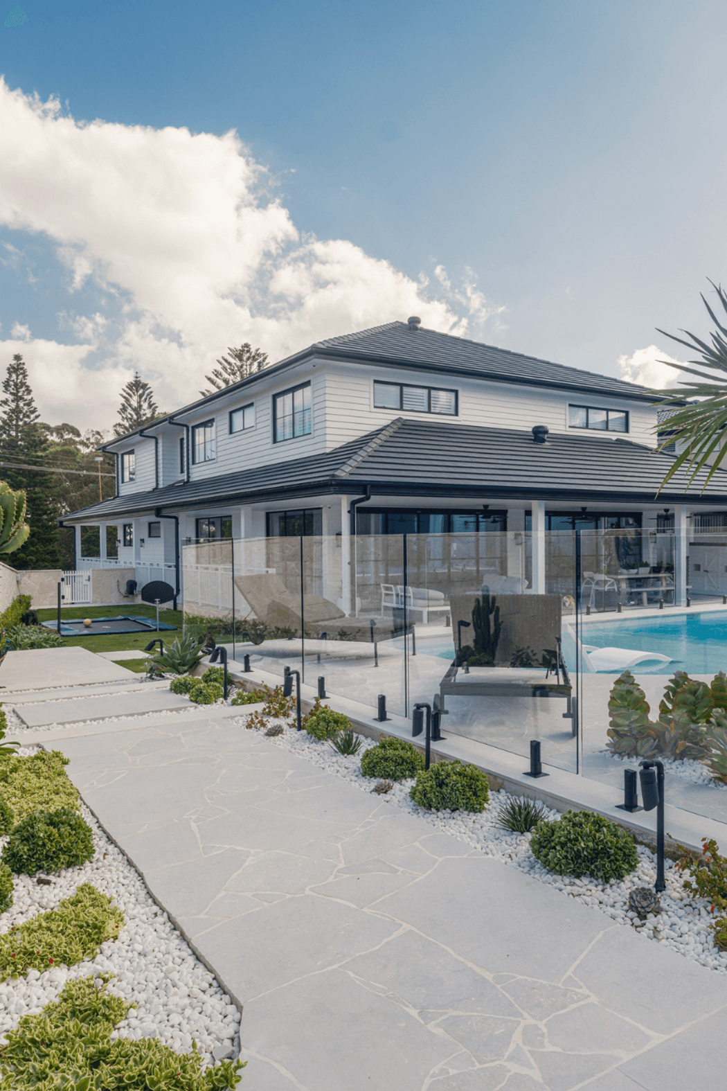Luna Chiaro Limestone creates a seamless pathway from garden to pool. Large format pavers define the entertainment zones, while crazy paving adds natural texture through landscaped beds, bringing the whole outdoor space together with one beautiful material.