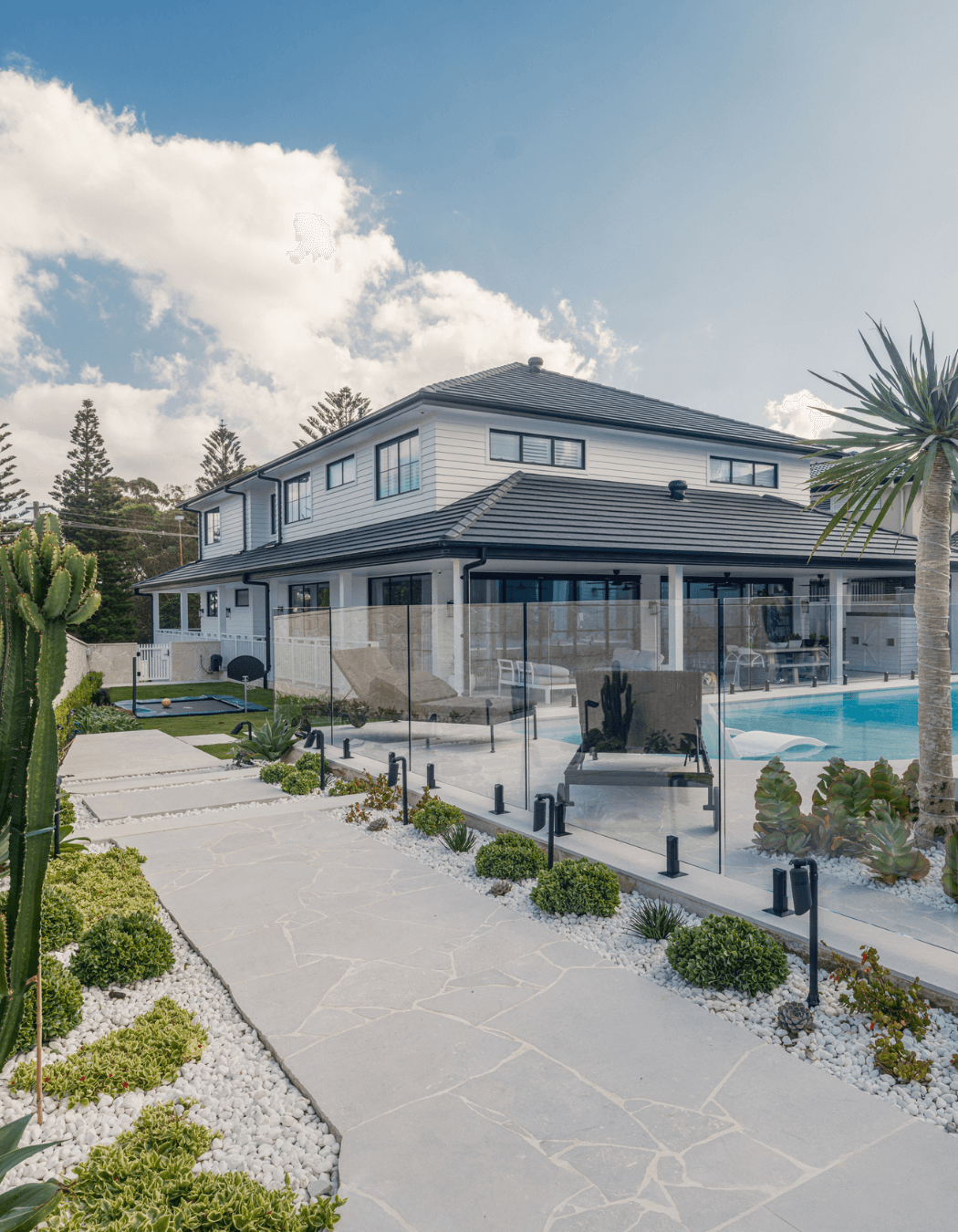 Luna Chiaro Limestone creates a seamless pathway from garden to pool. Large format pavers define the entertainment zones, while crazy paving adds natural texture through landscaped beds, bringing the whole outdoor space together with one beautiful material.