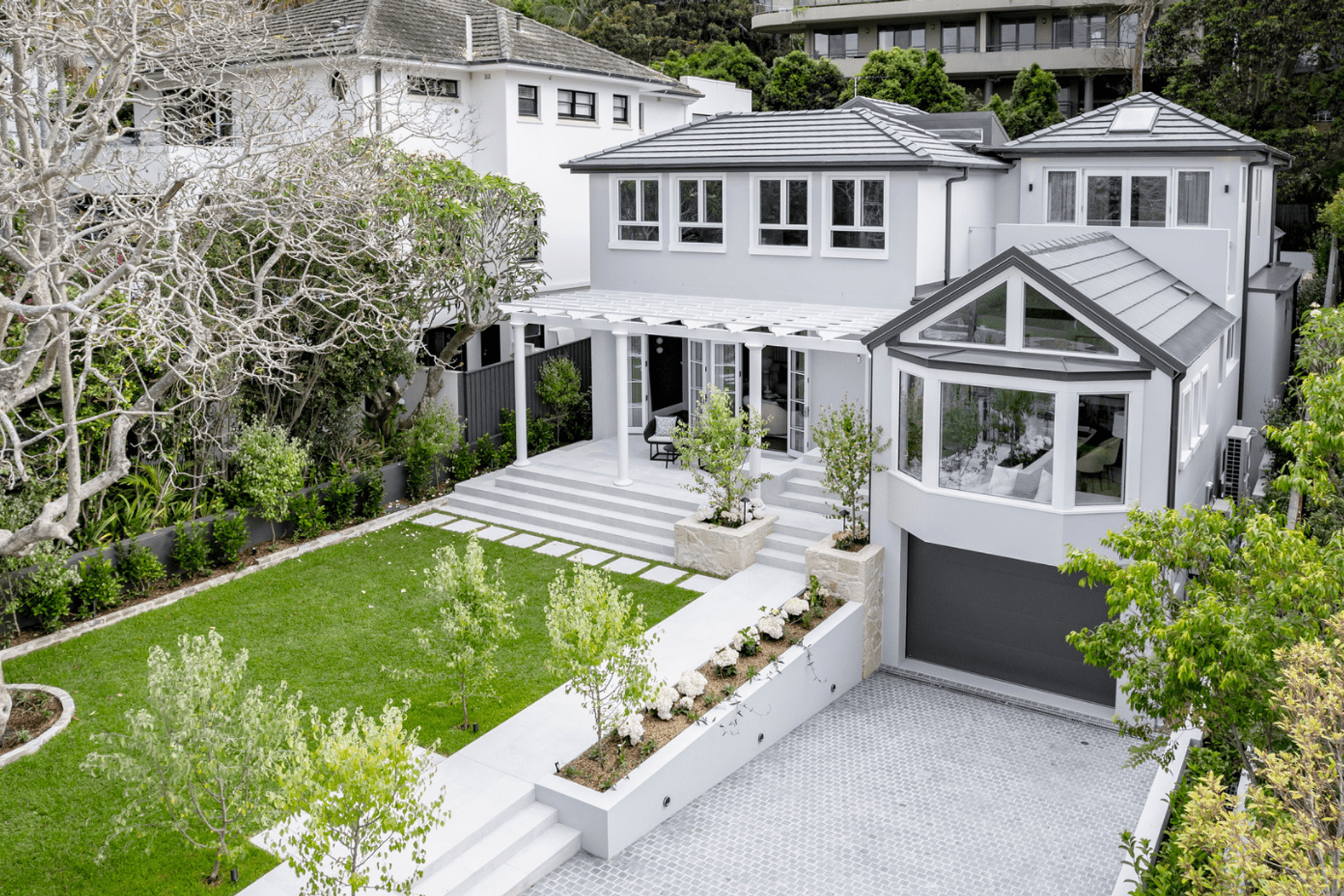 Luna Chiaro Limestone terraces and Silhouette Grey Granite Cobblestone driveway at Mosman family residence by hecticrAt architects.