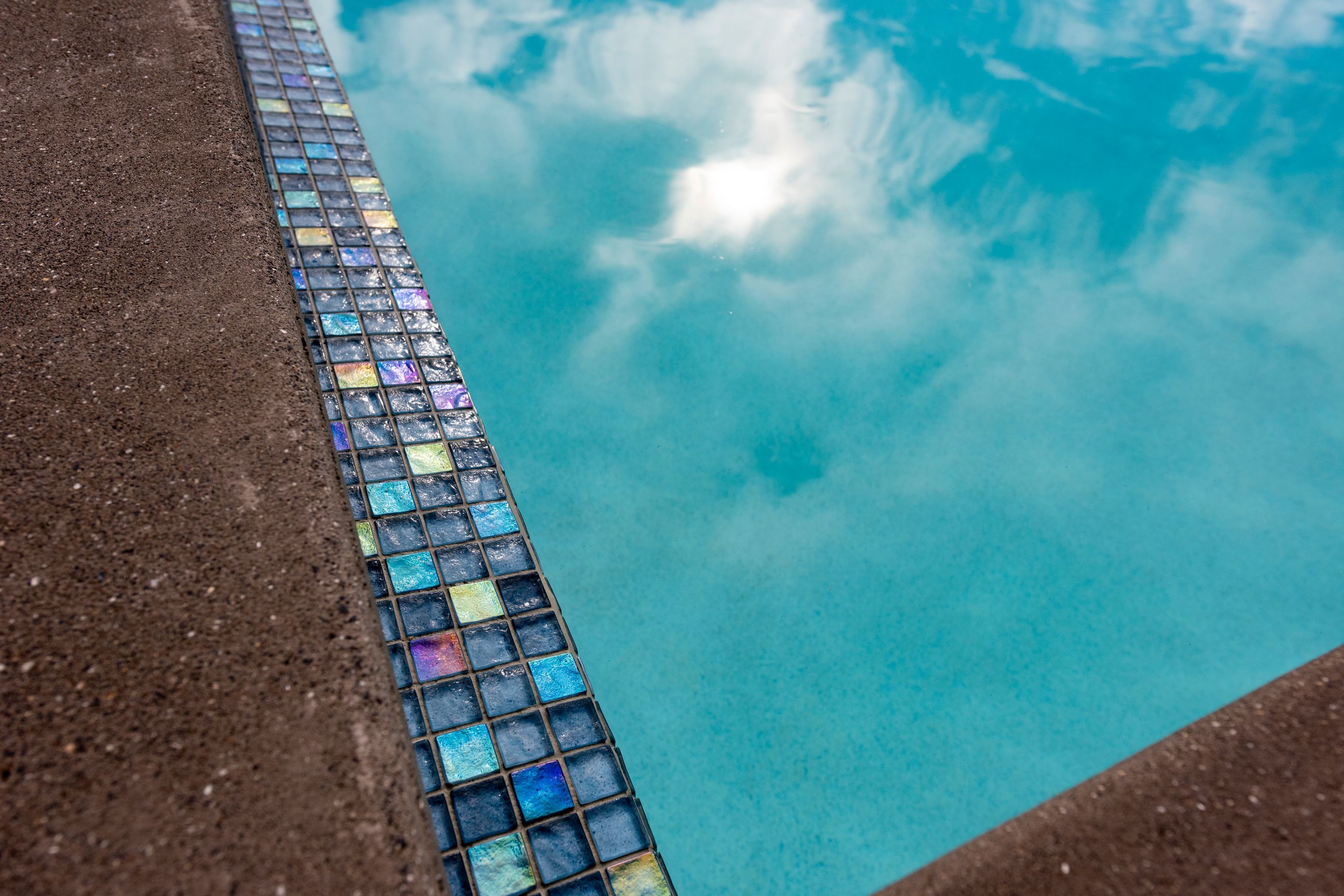 The Palmer & Allen Tiles used for the pool waterline and horizon edge can look very different across the space of the day, depending on how the sunlight captures them