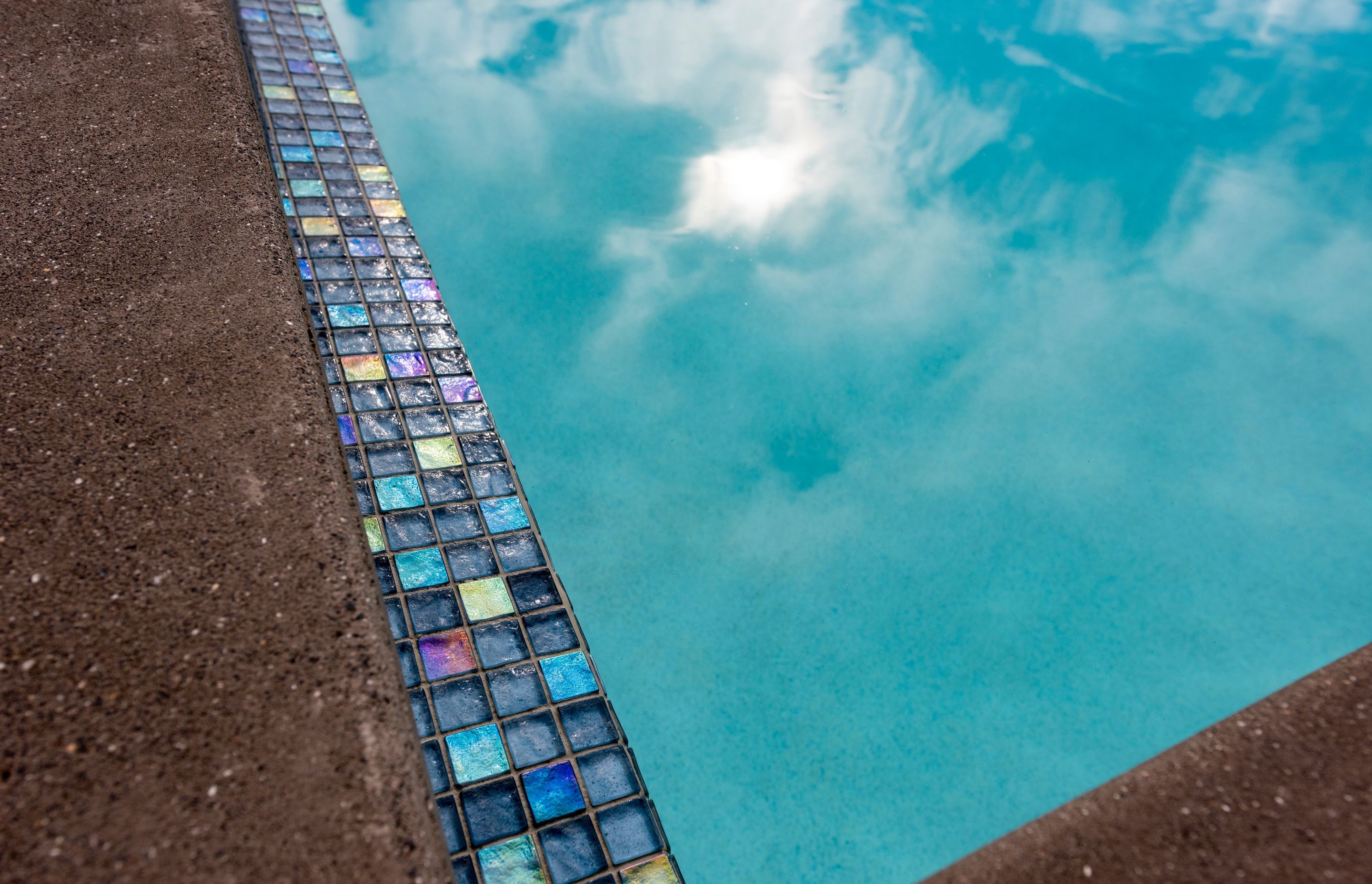 The Palmer &amp; Allen Tiles used for the pool waterline and horizon edge can look very different across the space of the day, depending on how the sunlight captures them