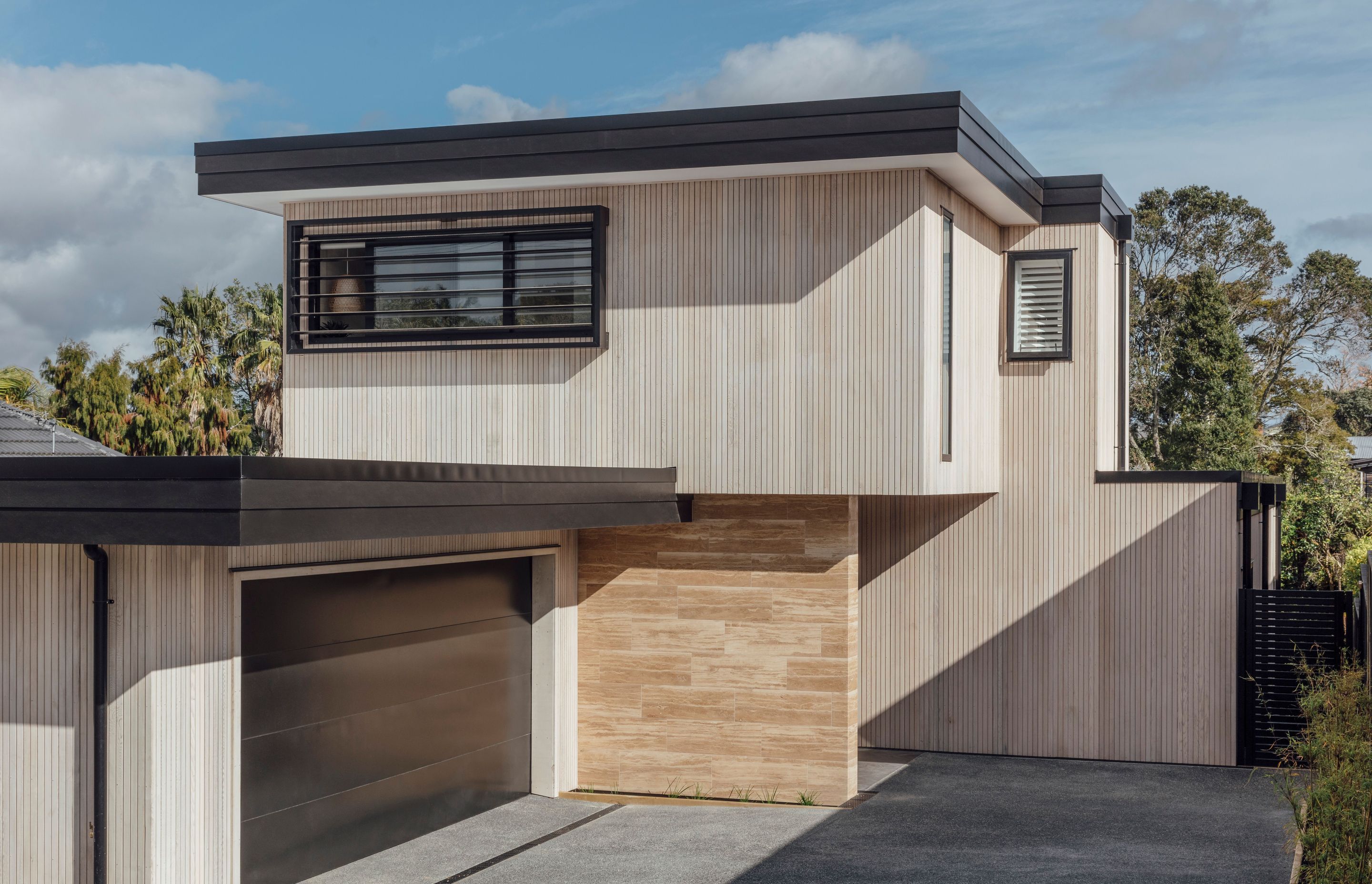 From the street, the home, with its horizontal roof planes, looks decidedly modern. The cladding of narrow cedar board runs vertically in gentle counterpoint.