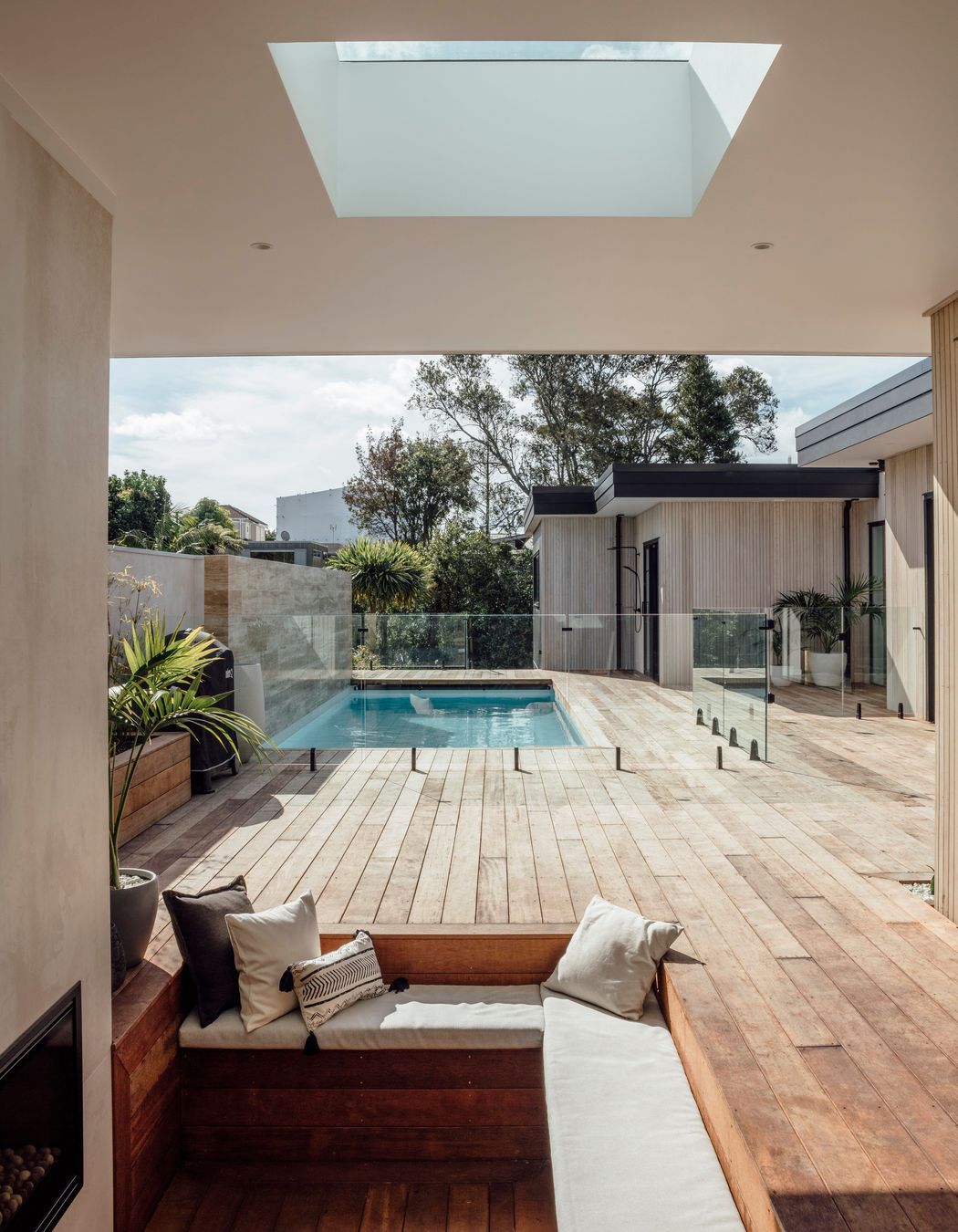Tucked into the corner, a conversation pit with open fire provides a more intimate space within the wider outdoor entertaining area.