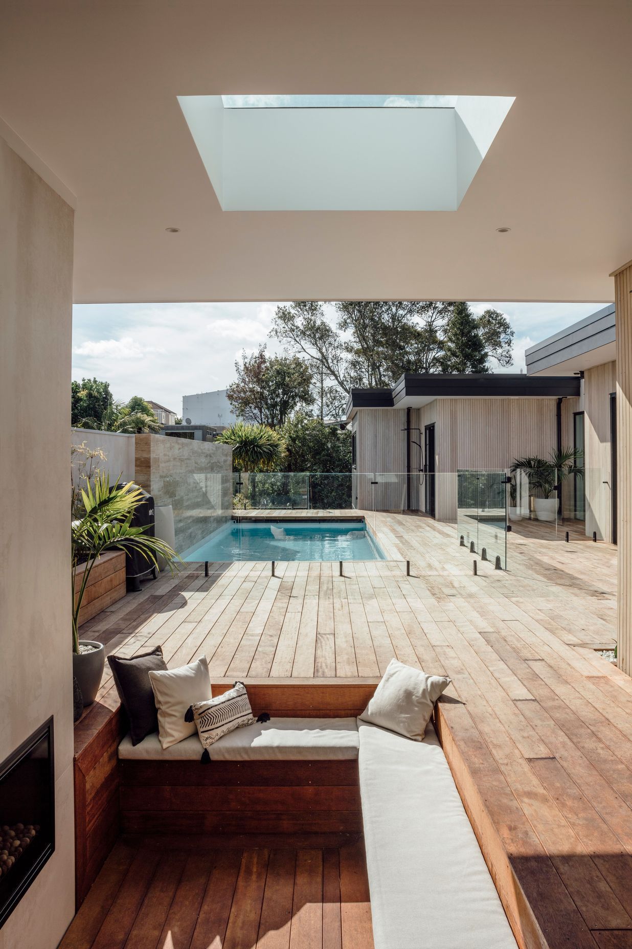 Tucked into the corner, a conversation pit with open fire provides a more intimate space within the wider outdoor entertaining area.