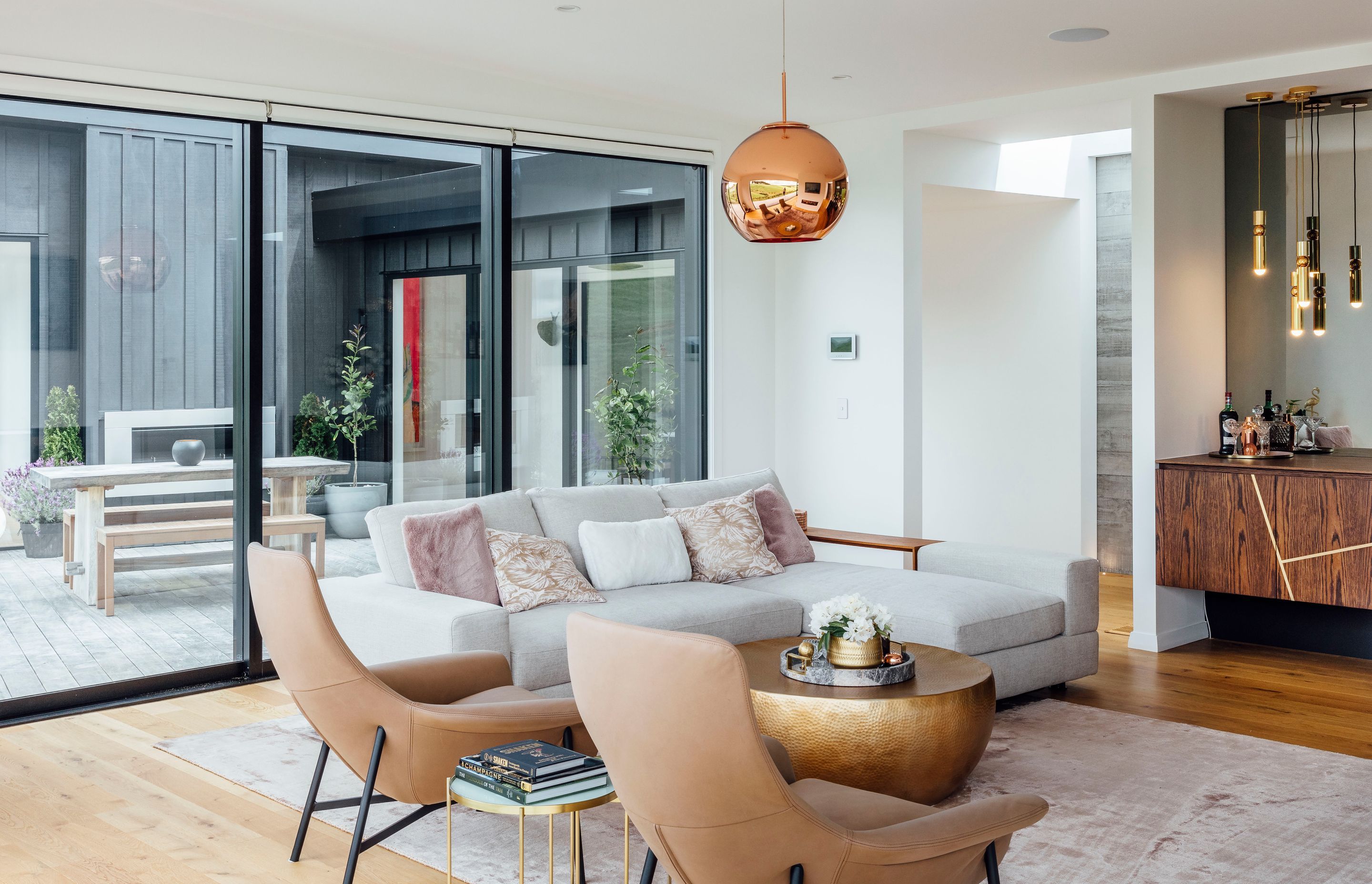 In the living area, Quick-Step compact flooring in 'Natural Oak' has an extra-matt finish. A Valentina rug in 'Blush' from Coco Republic was chosen to define the lounge, where a beaten brass drum coffee table from Freedom teams with Seymour chairs and a J