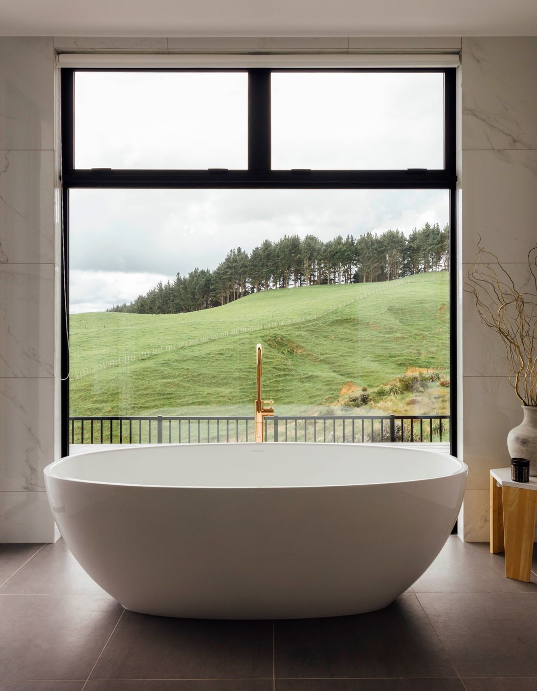 Rose gold Progetto Buddy Tapware has a modern elegance alongside the Victoria &amp; Albert Barcelona bath and polished porcelain Verona white wall tiles.