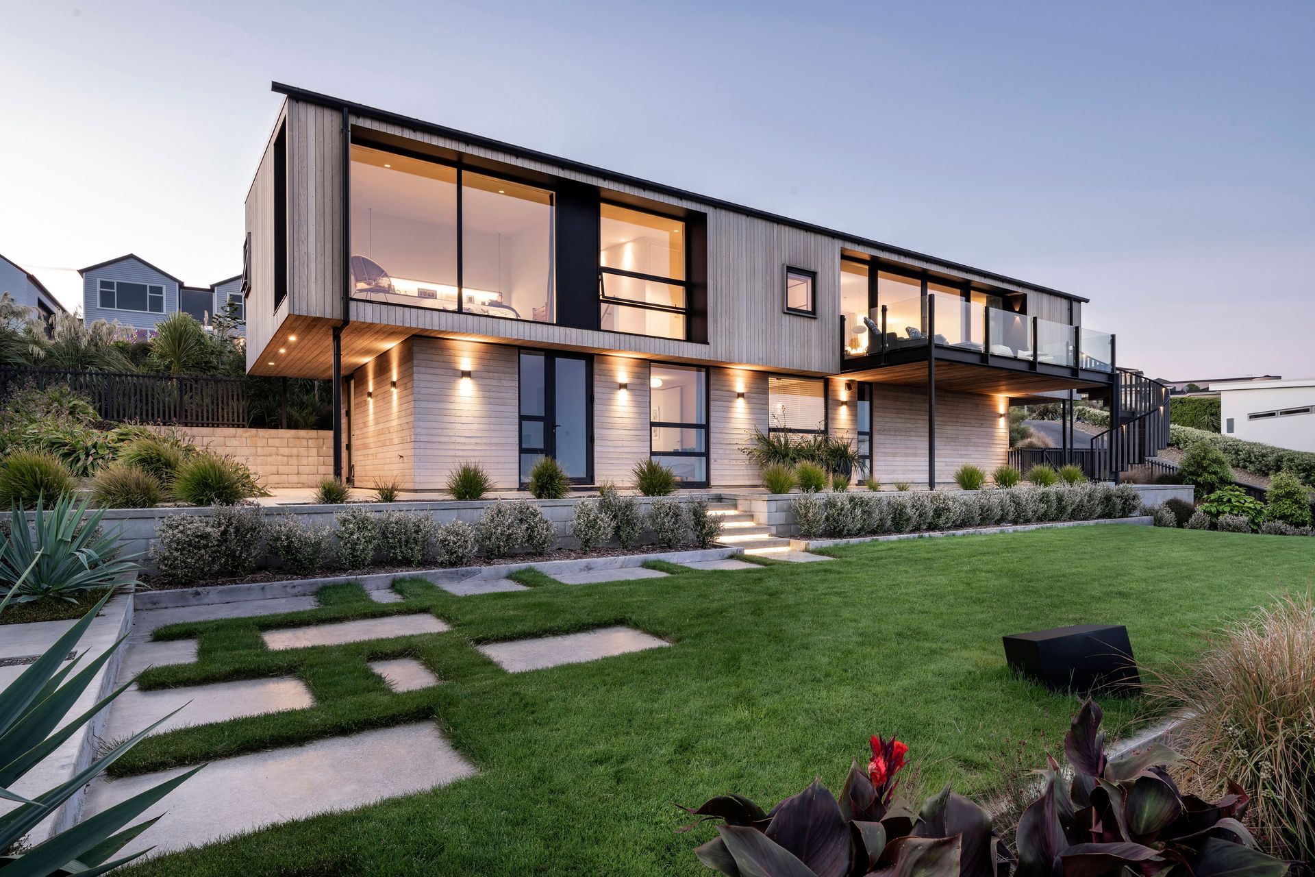 The lawn terrace below the house. Concrete stepping stones lead to a seating area
