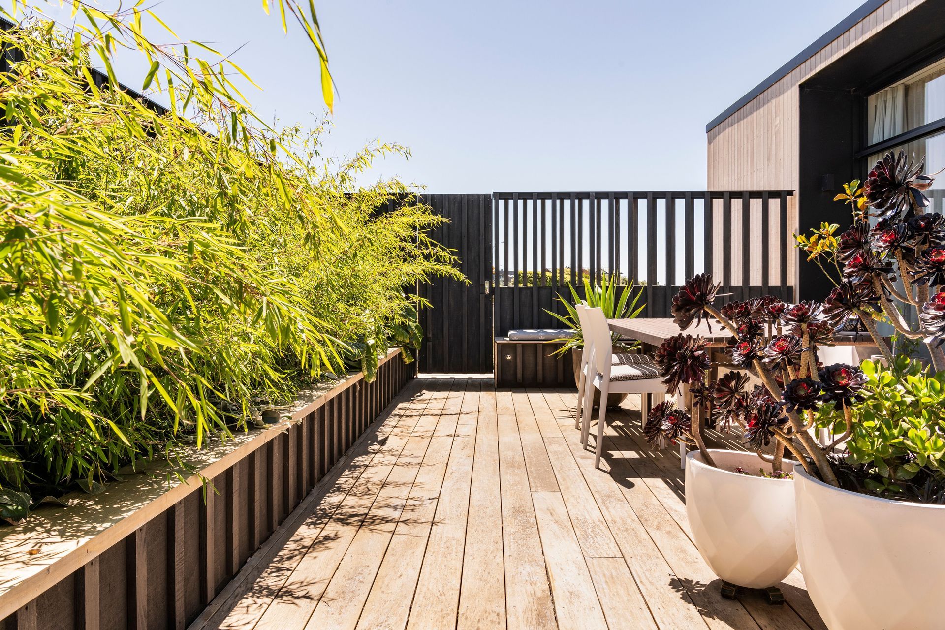 Custom timber screens together with lush planting create a private outdoor dining and entertainment area