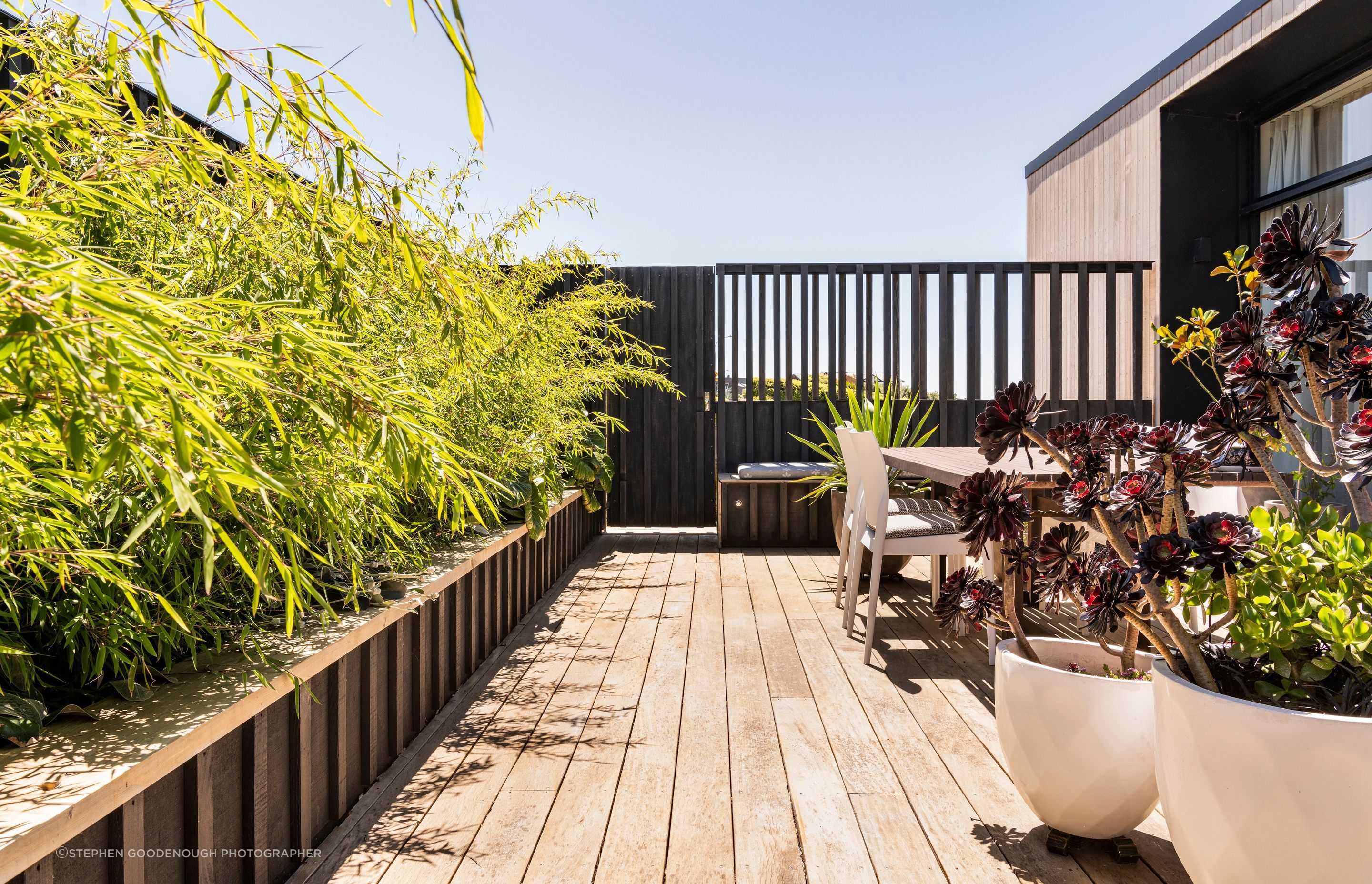 Custom timber screens together with lush planting create a private outdoor dining and entertainment area