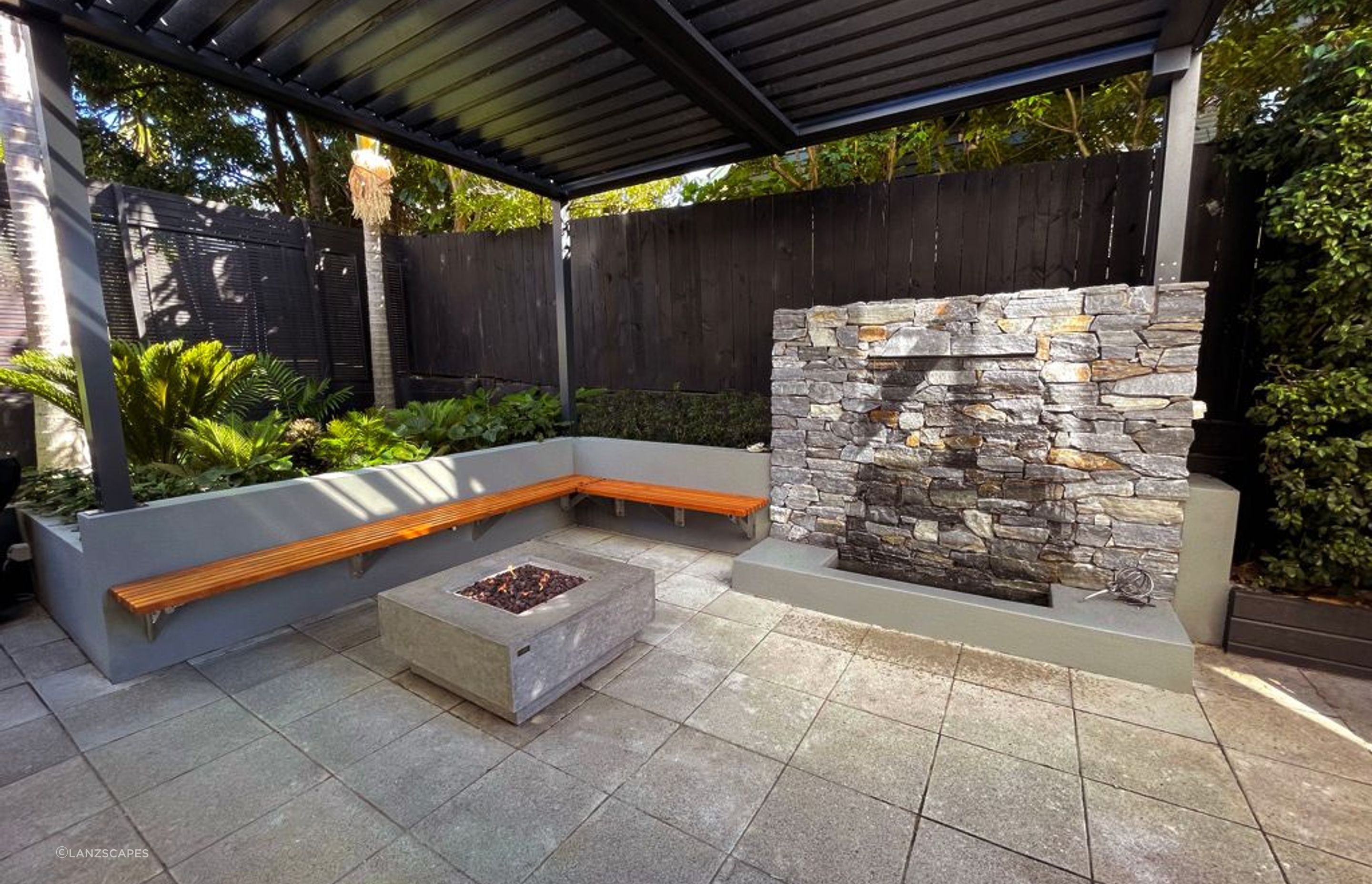 Patio with Locarno Louvered pergola, fire pit and water feature