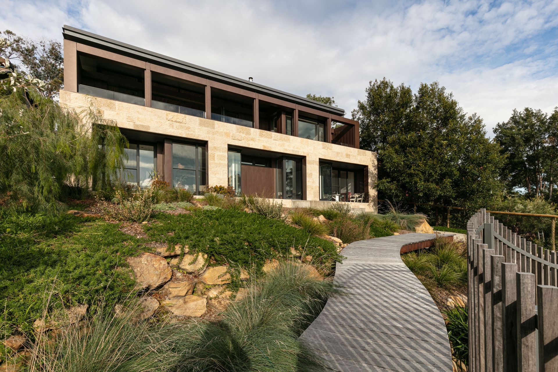 The house is grounded to the native bushland with stone and corten cladding and a native garden design.