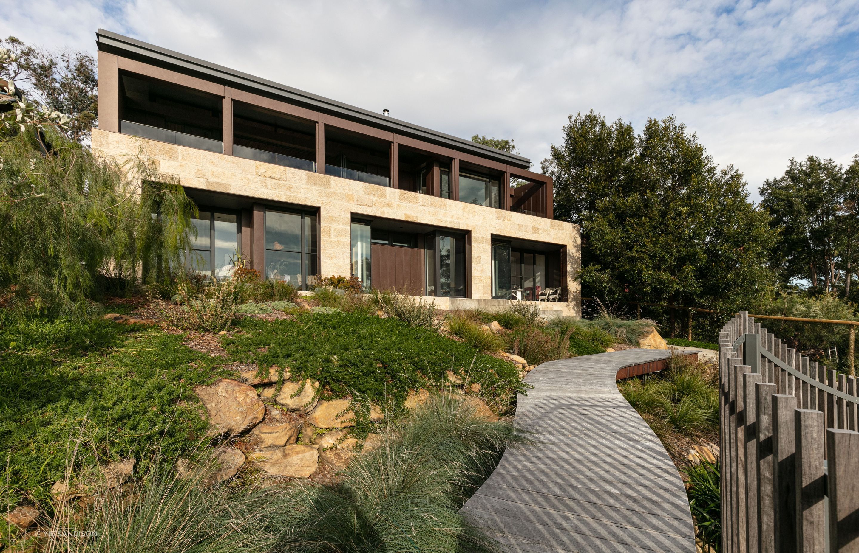 The house is grounded to the native bushland with stone and corten cladding and a native garden design.