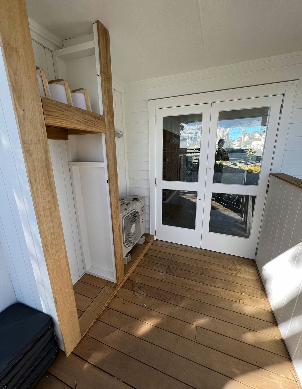 Custom outdoor storage solution built on the patio next to the backdoor and air conditioner