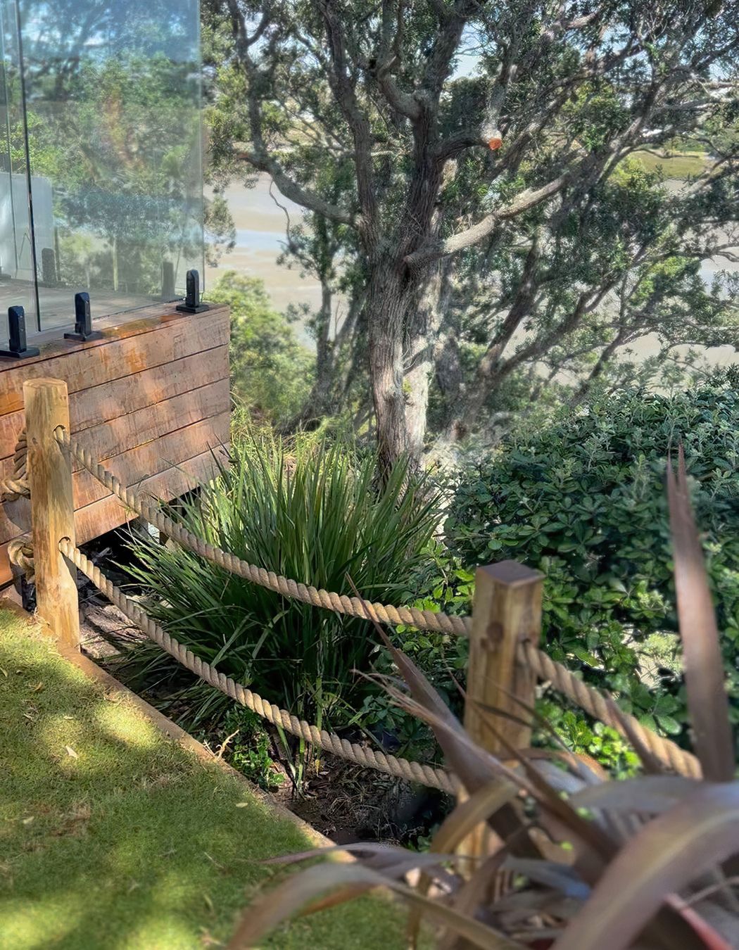 Custom rope fence with wood posts and heaps trees and bushes on the opposing side