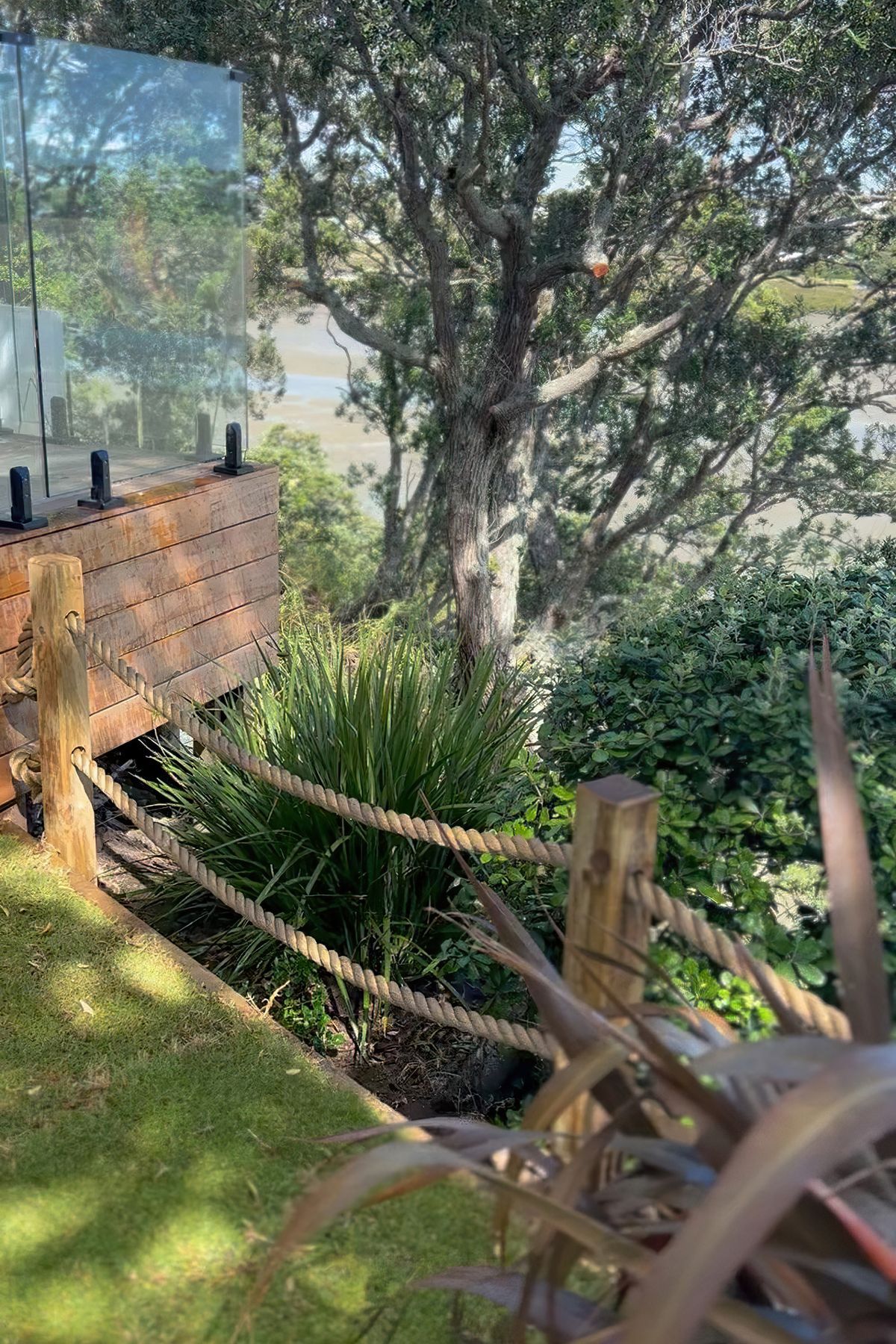 Custom rope fence with wood posts and heaps trees and bushes on the opposing side