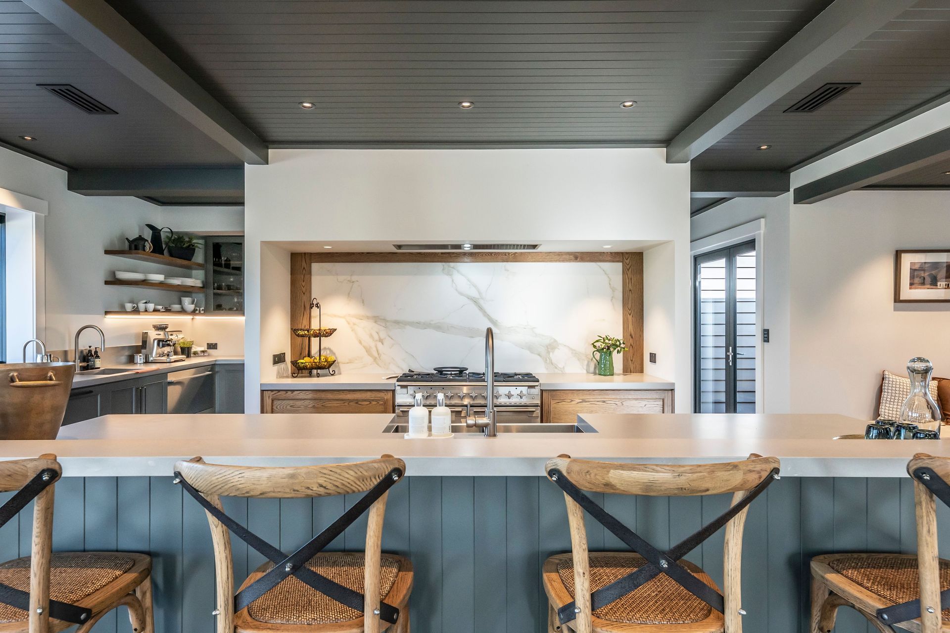 A large island bench separates the living area from the well-appointed kitchen.