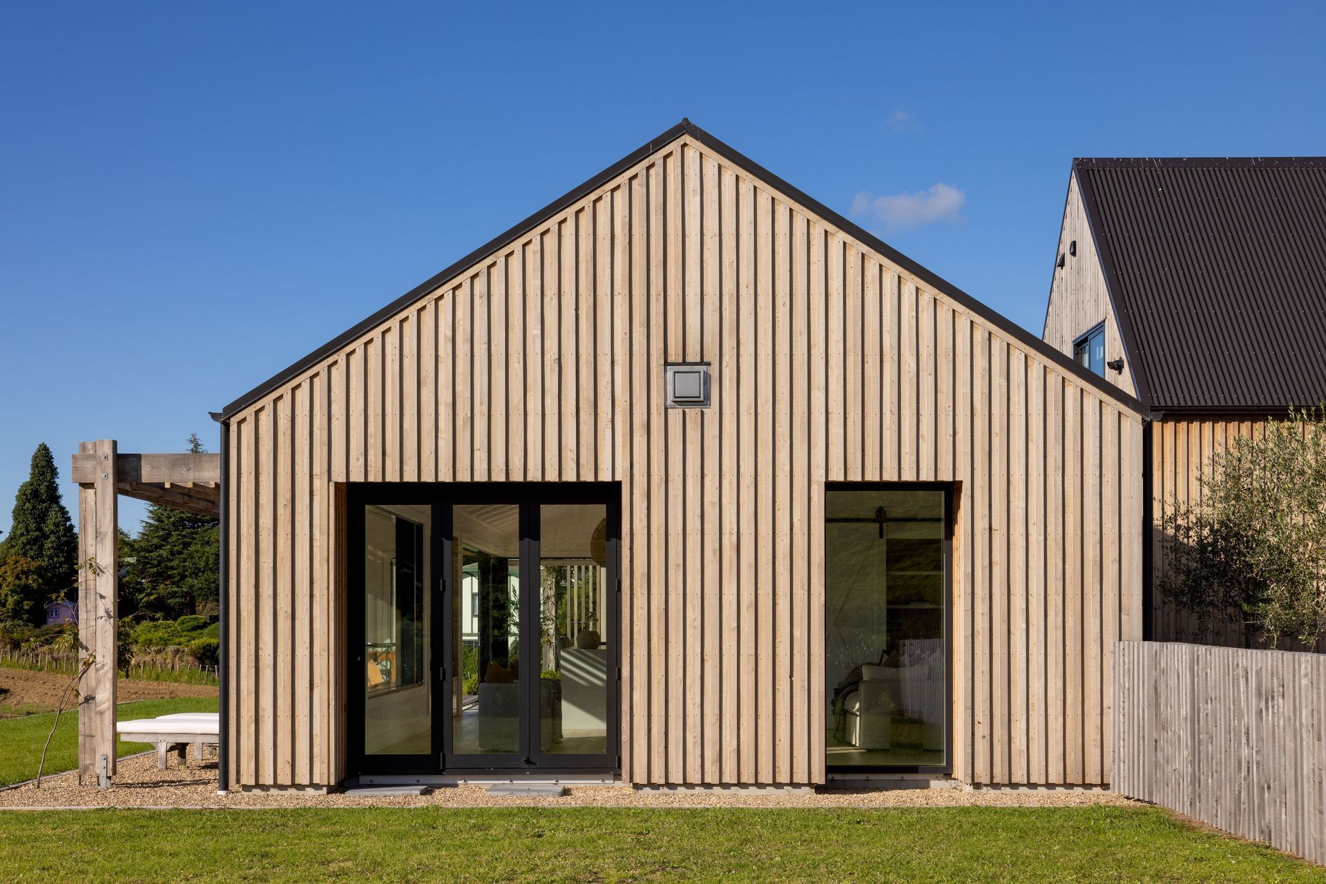 The distinct forms of the living space and garage space (with a guest suite above it) are haphazardly arranged together much like traditional rural buildings.