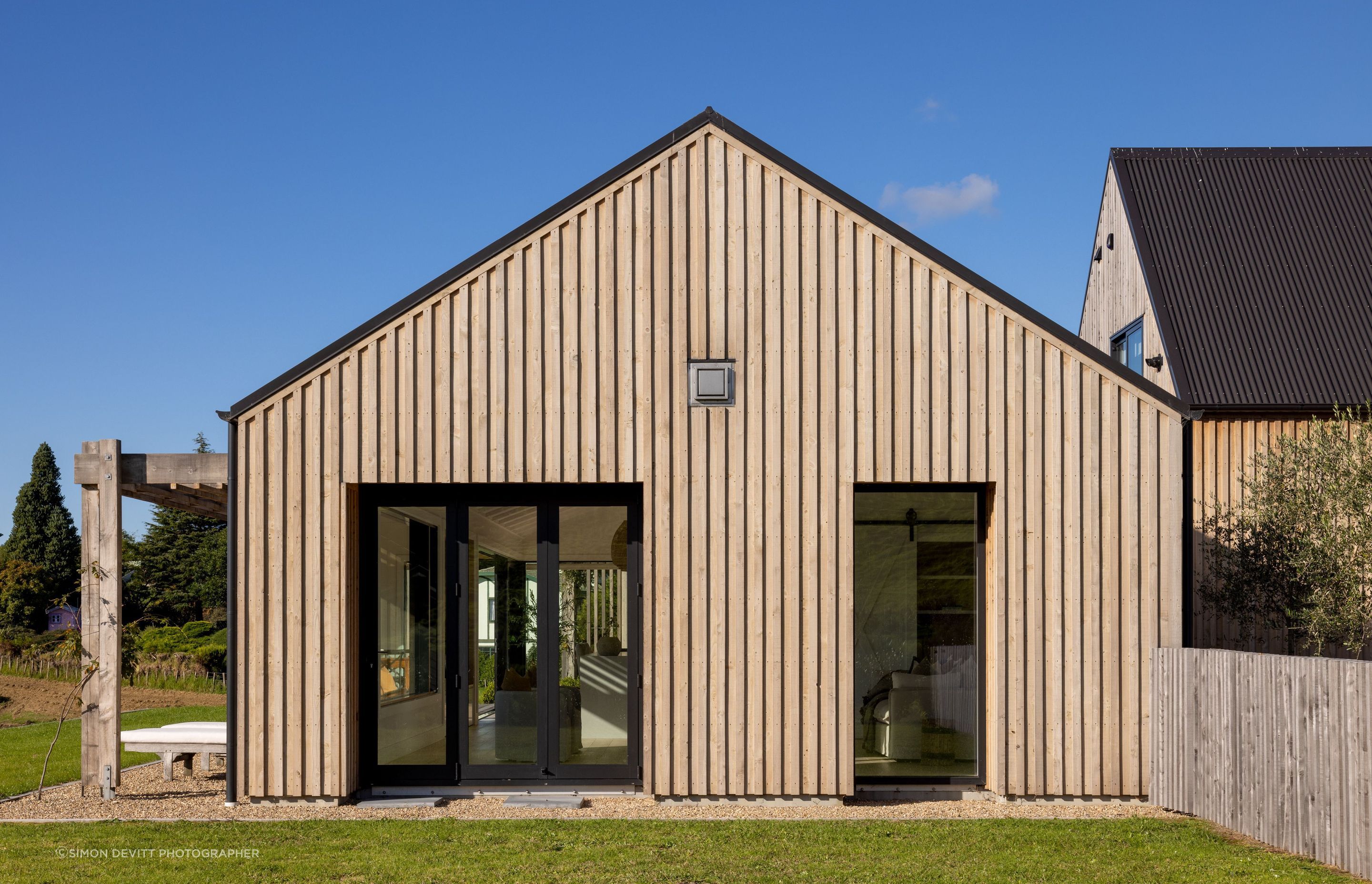 The distinct forms of the living space and garage space (with a guest suite above it) are haphazardly arranged together much like traditional rural buildings.