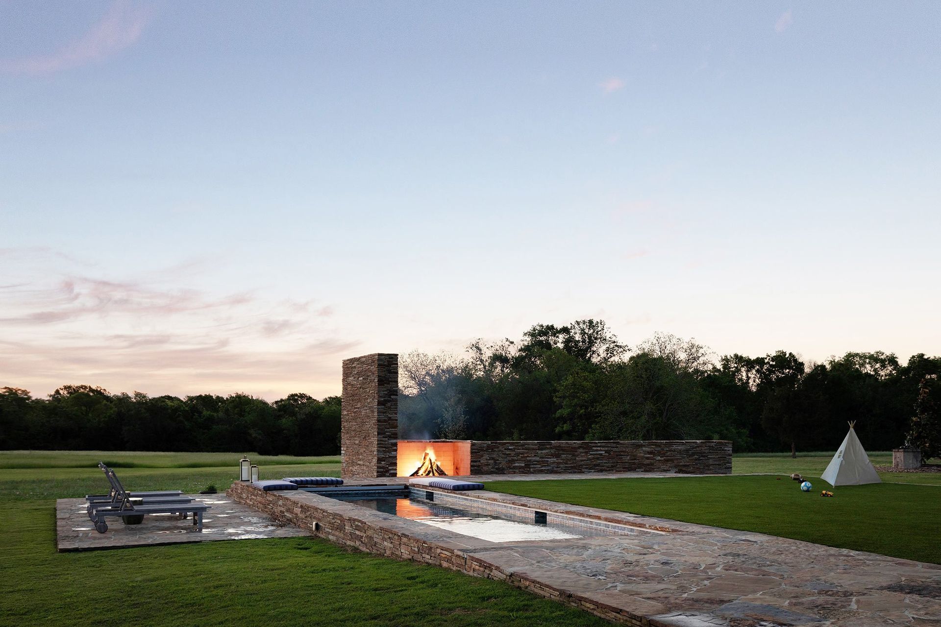 21HomeontheRangeCuppettKilpatrickArchitectureandInteriorDesignoutdoor-pool-fireplace-stone-twilight.jpg