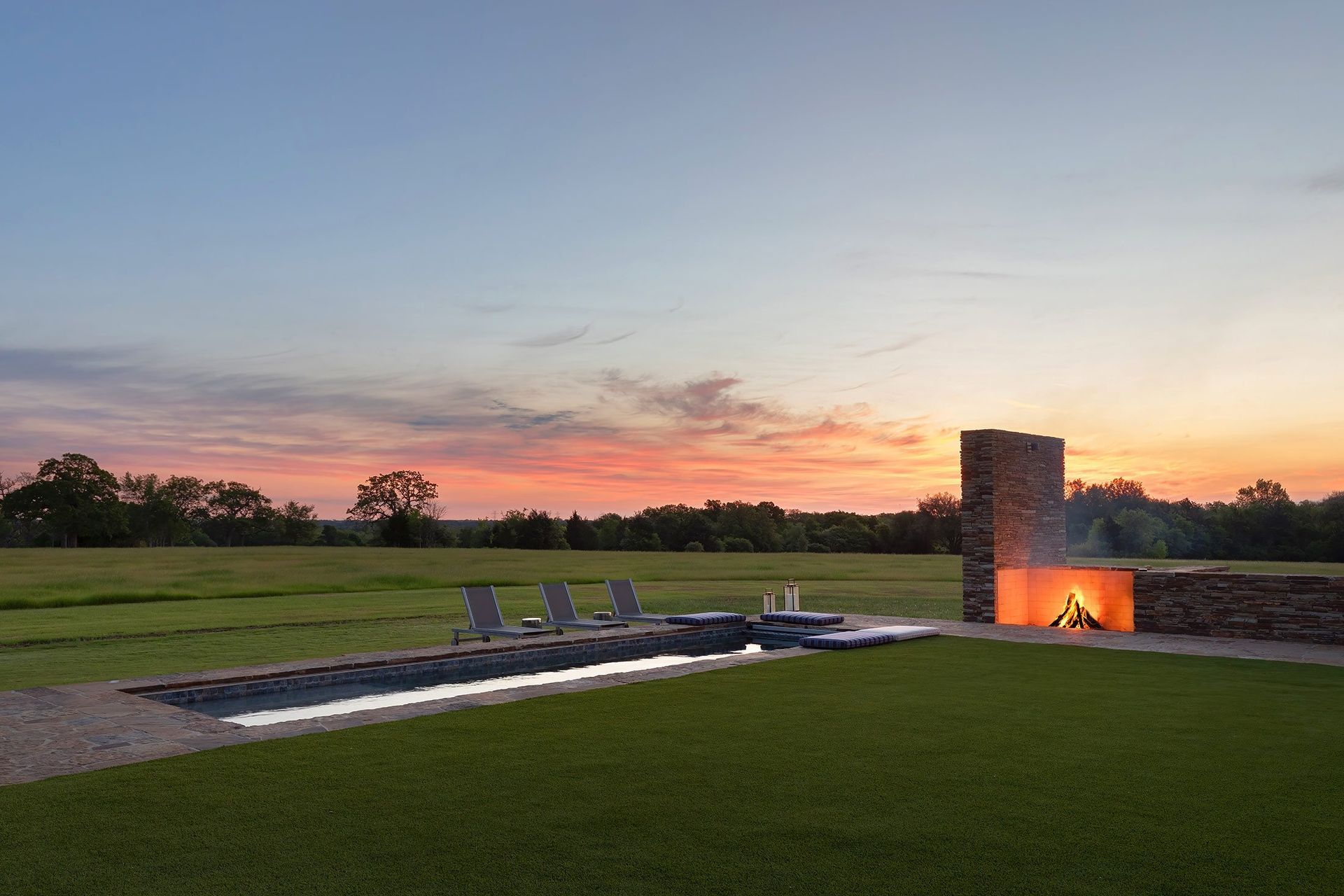 22HomeontheRangeCuppettKilpatrickArchitectureandInteriorDesignsunset-pool-fireplace-lounge-chairs-sky.jpg