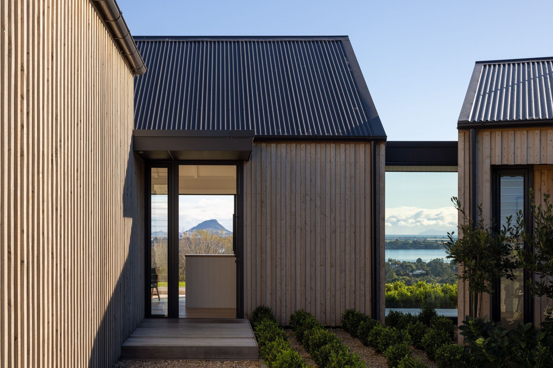 The unostentatious entry is accessed to the right of the garage and leads visitors directly into the living spaces; a glass atrium to the right of the entry enforces separation between the living and bedroom spaces, while also offering visitors a sneak p