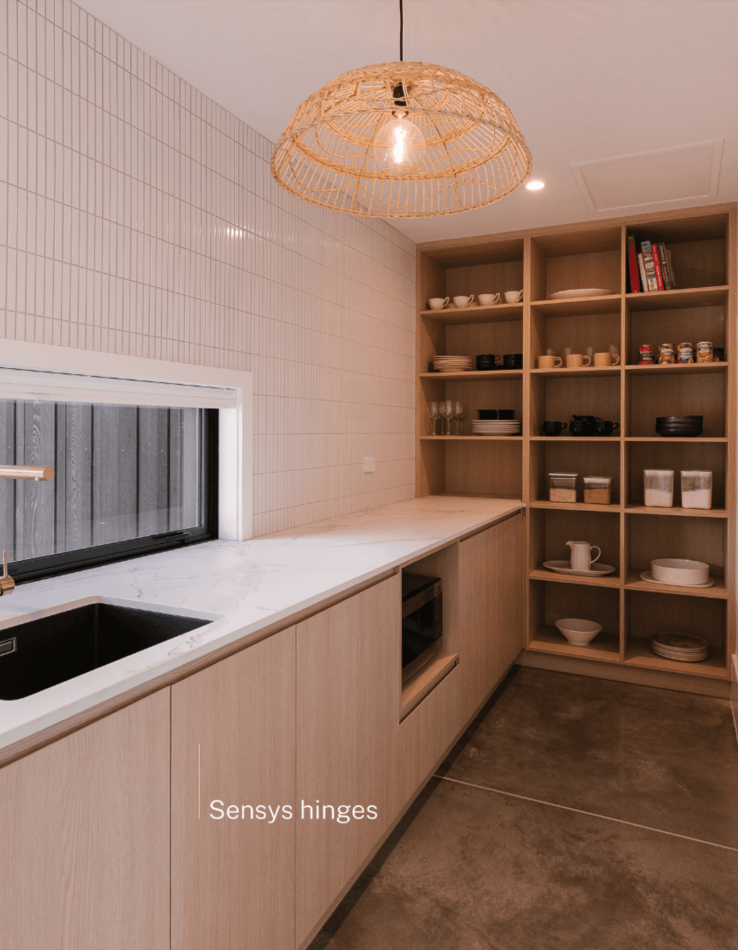 Warm natural doors complement a beige scullery using soft-closing Sensys hinges