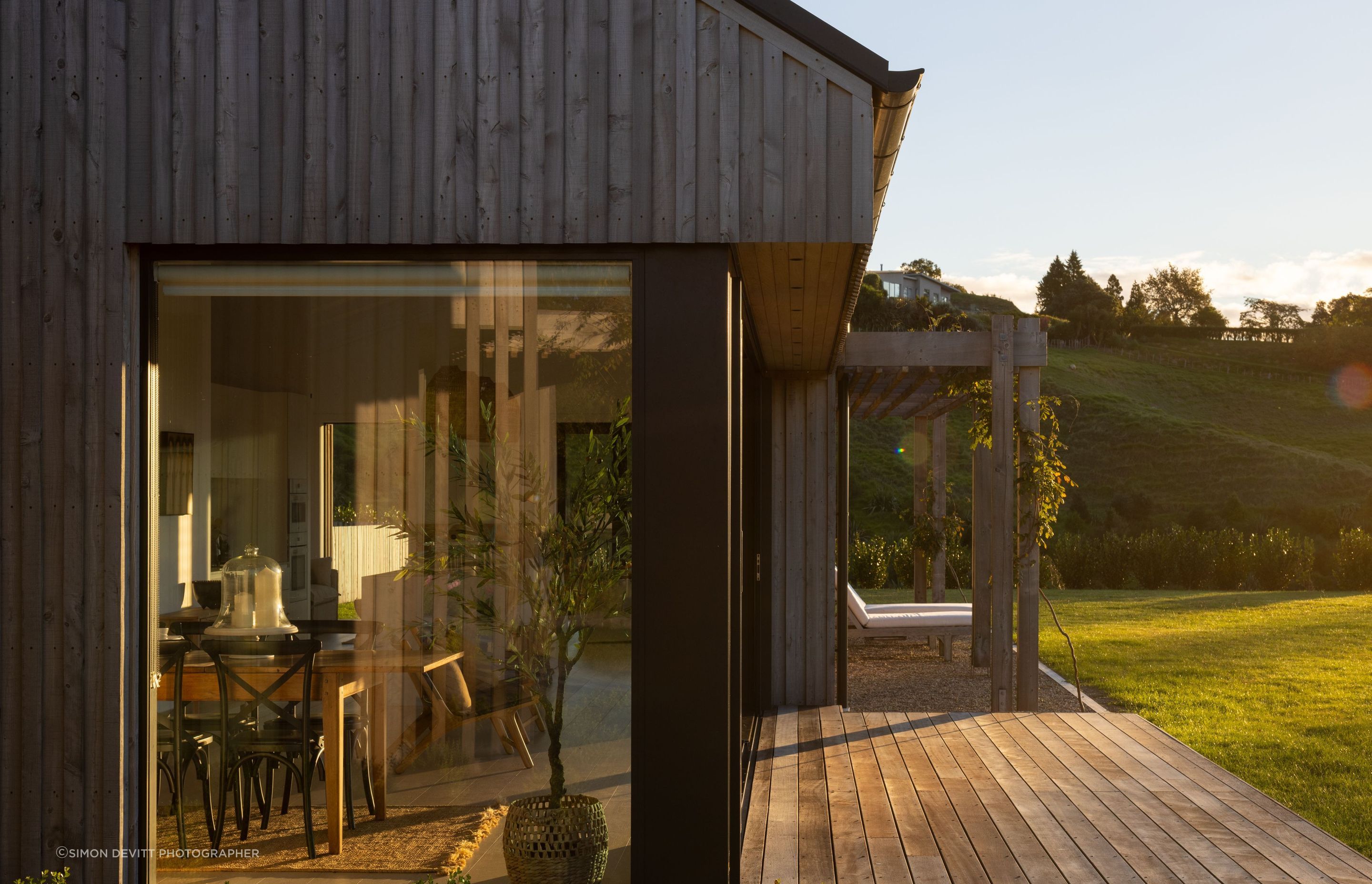 The sun sets over the living spaces pod; the extensive glazing on the northern side means the house is warm year-round.