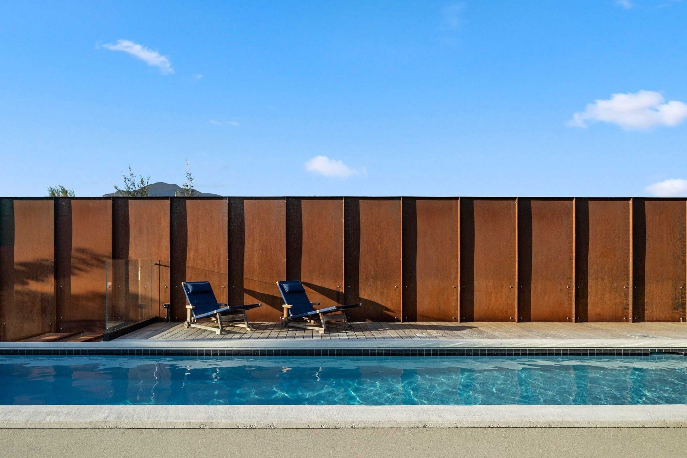 Custom Corten panels have been used to create a fence that not only provides privacy but will also continue to patina over time adding an element of permanency and immutability.