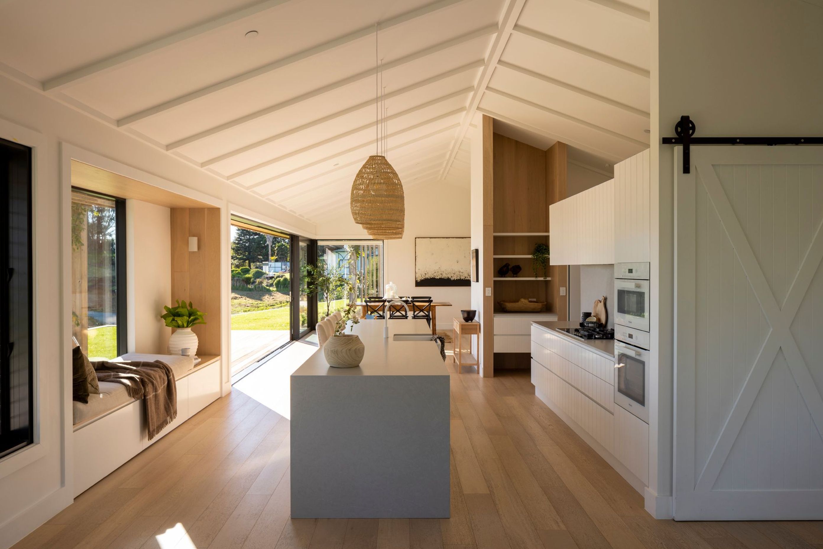 The kitchen/dining space is light and bright, with pale oak floorboards and a kitchen featuring V-groove panelling.