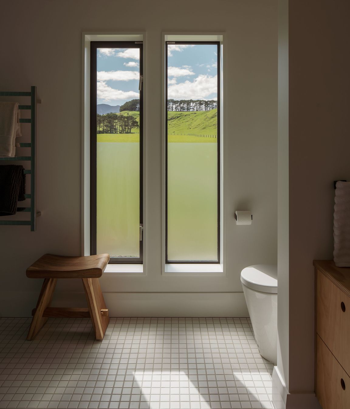 The neutral palette extends to the bathrooms, which are almost austere in their simplicity, yet this is tempered by the use of plywood accents.