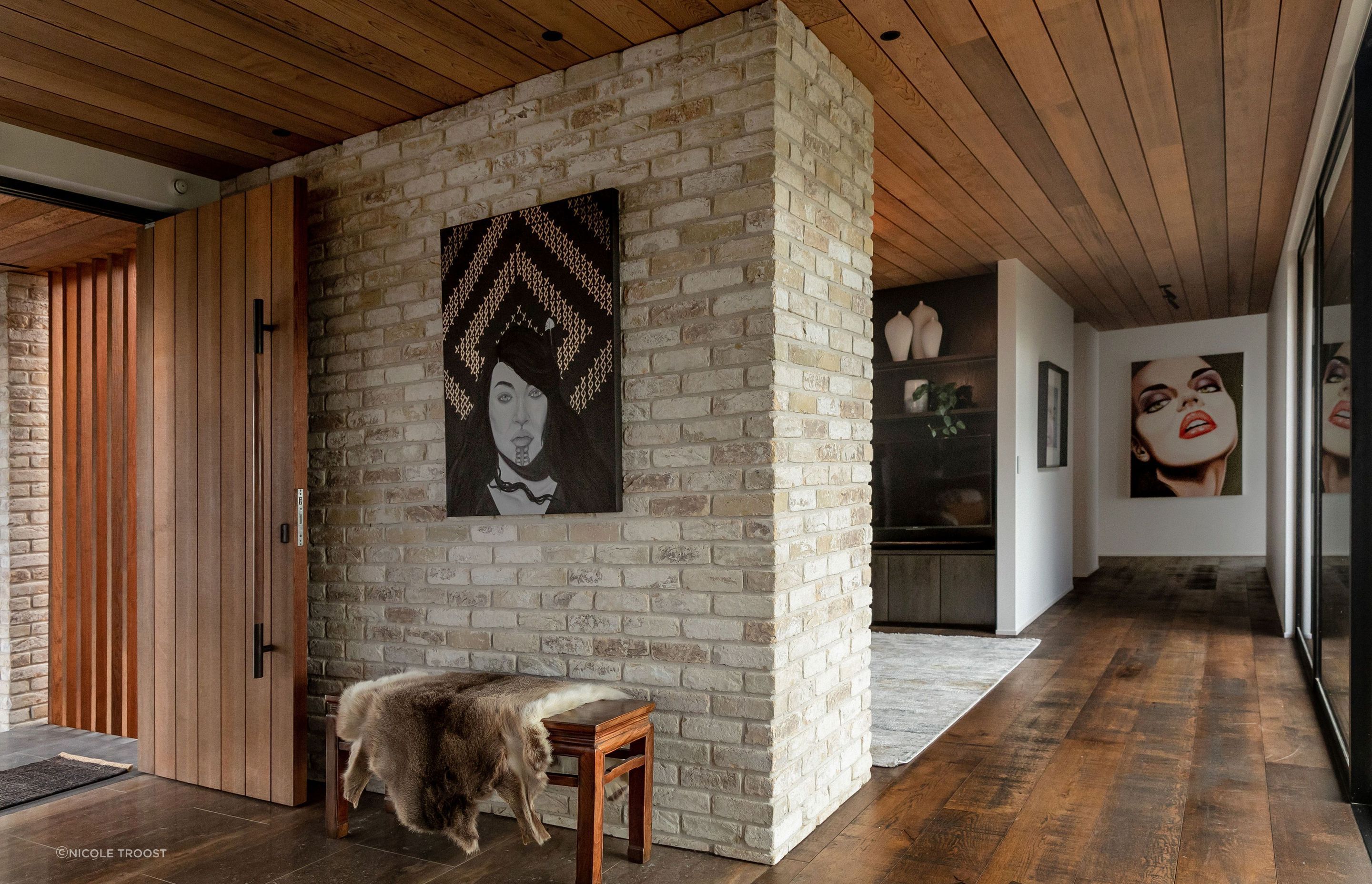 The entry is modest in volume and the hallway (with a library nook off it) leads to the guest wing and second living space.