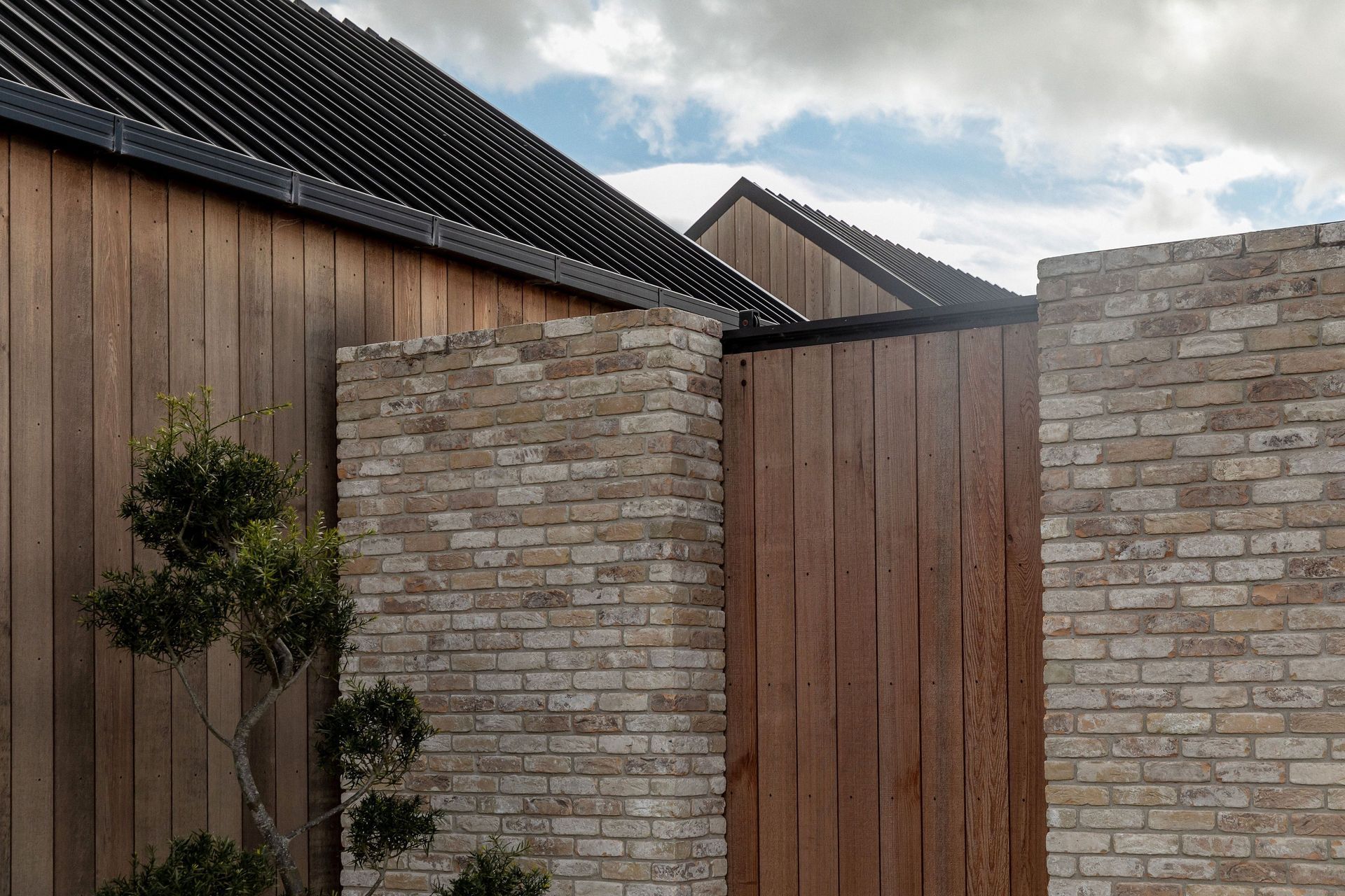 The juxtaposition of cedar, black steel  and pale brick forms a rich exterior materiality.