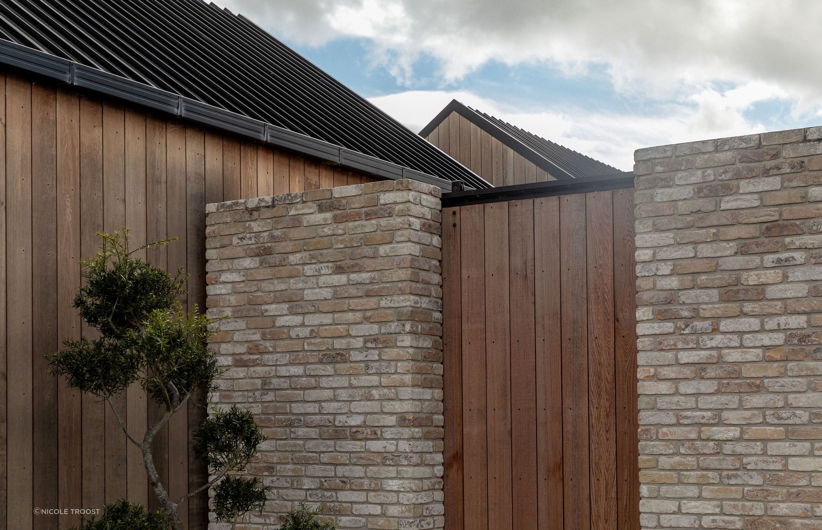 The juxtaposition of cedar, black steel  and pale brick forms a rich exterior materiality.