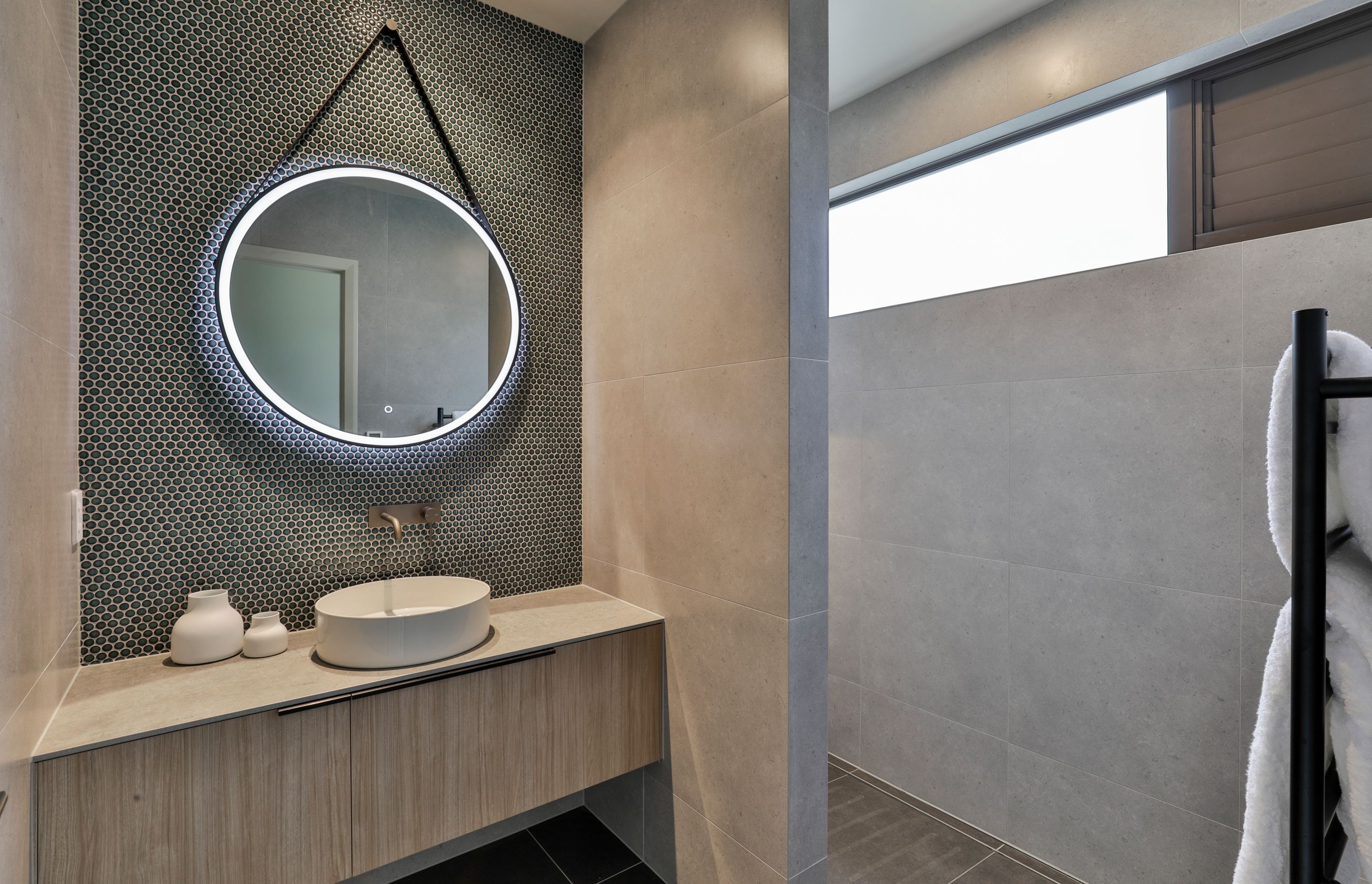 Design by Cube Dentro. Tiles: Cordoba Black 600x600mm on the floor with Cordoba Pearl 600x600mm on the walls. Mosaix Penny Round Jade feature wall behind vanity.