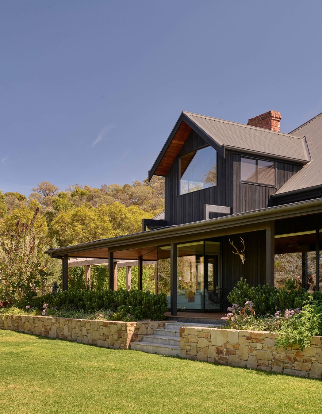Corrugated iron roofing in Monument by Colorbond. Charred timber cladding from Eco Timber Group. Tallowwood lining from Eco Timber Group. Hand built Castlemaine limestone wall. Endicott paving by Eco Outdoor on stairs.