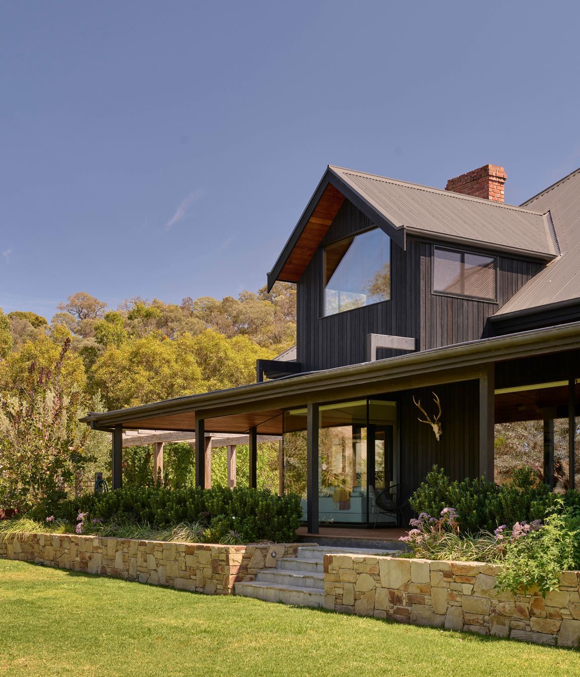 Corrugated iron roofing in Monument by Colorbond. Charred timber cladding from Eco Timber Group. Tallowwood lining from Eco Timber Group. Hand built Castlemaine limestone wall. Endicott paving by Eco Outdoor on stairs.