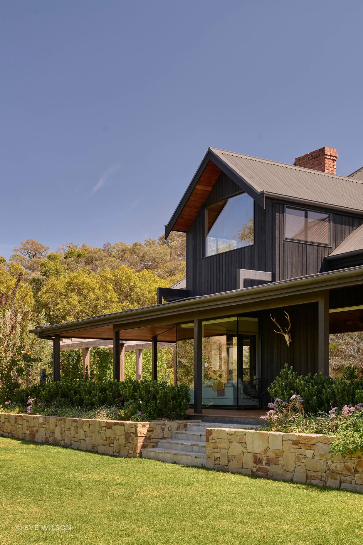 Corrugated iron roofing in Monument by Colorbond. Charred timber cladding from Eco Timber Group. Tallowwood lining from Eco Timber Group. Hand built Castlemaine limestone wall. Endicott paving by Eco Outdoor on stairs.